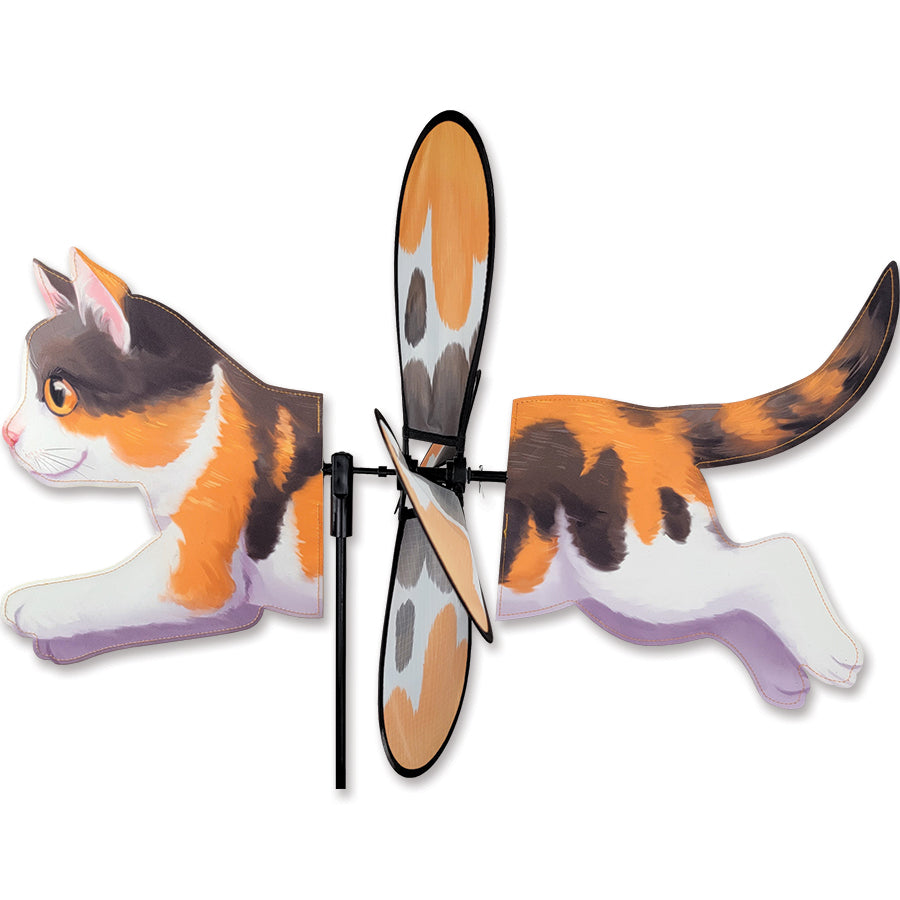 Deluxe Petite Spinner featuring a calico cat design, spinning gracefully in a garden, showcasing its colorful and playful appearance.