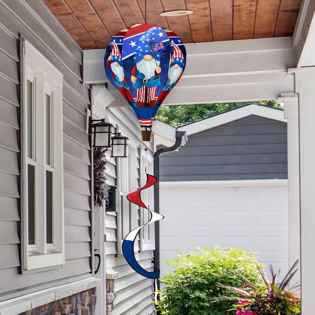 Hot air balloon spinner featuring patriotic gnomes, flags, and fireworks, made of weather-resistant polyester for lively outdoor summer holiday décor.