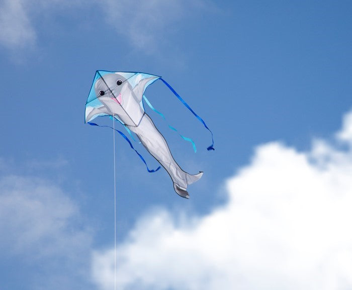 Dolphin 45-inch Fly-Hi Kite flying high in a blue sky, featuring a vibrant dolphin design and colorful streamer tails.