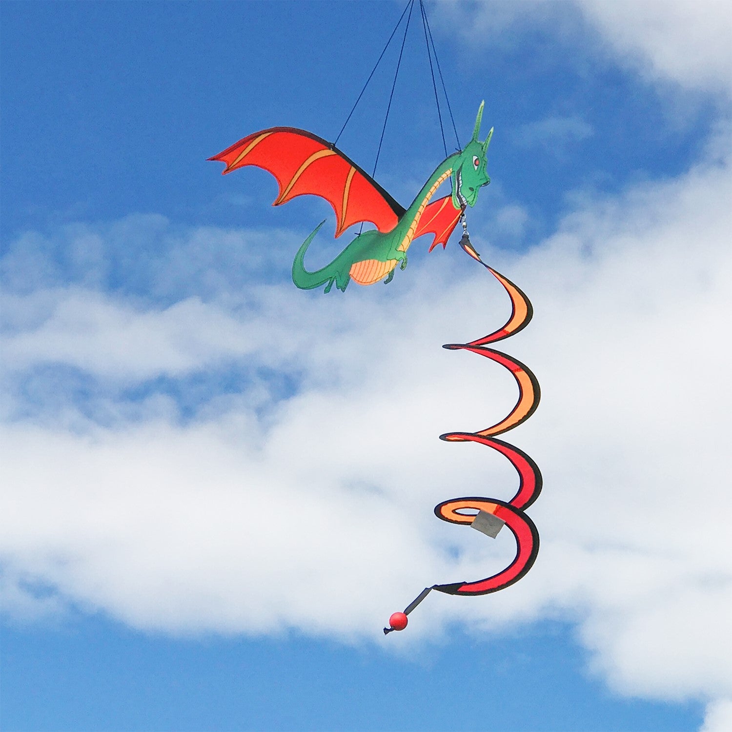 Dragon Theme Twister with moveable wings and colorful design spinning in the breeze, hung in a vibrant garden setting.