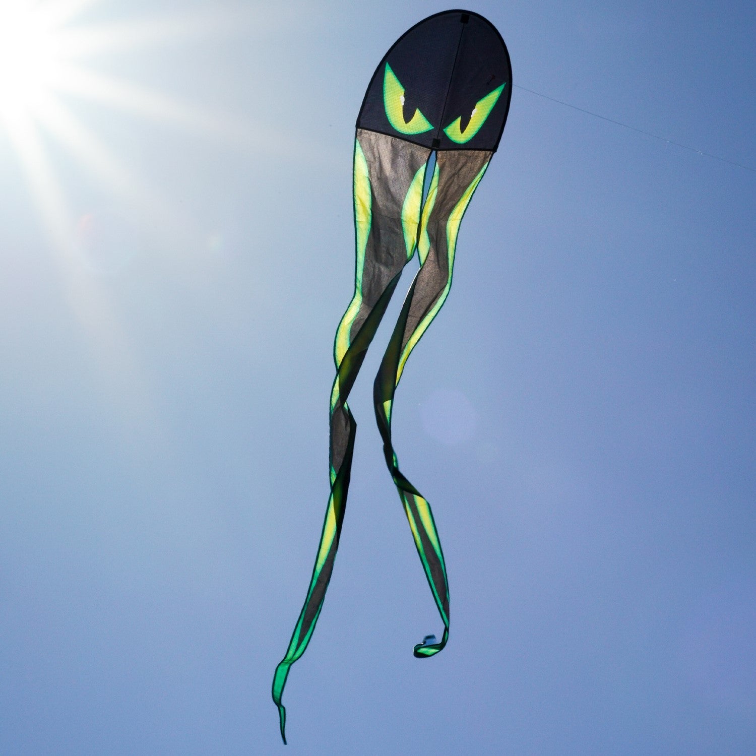22-Inch Eyes Dancing Dragon Kite soaring in the sky with flowing tails, showcasing vibrant colors and a spooky design during outdoor play.