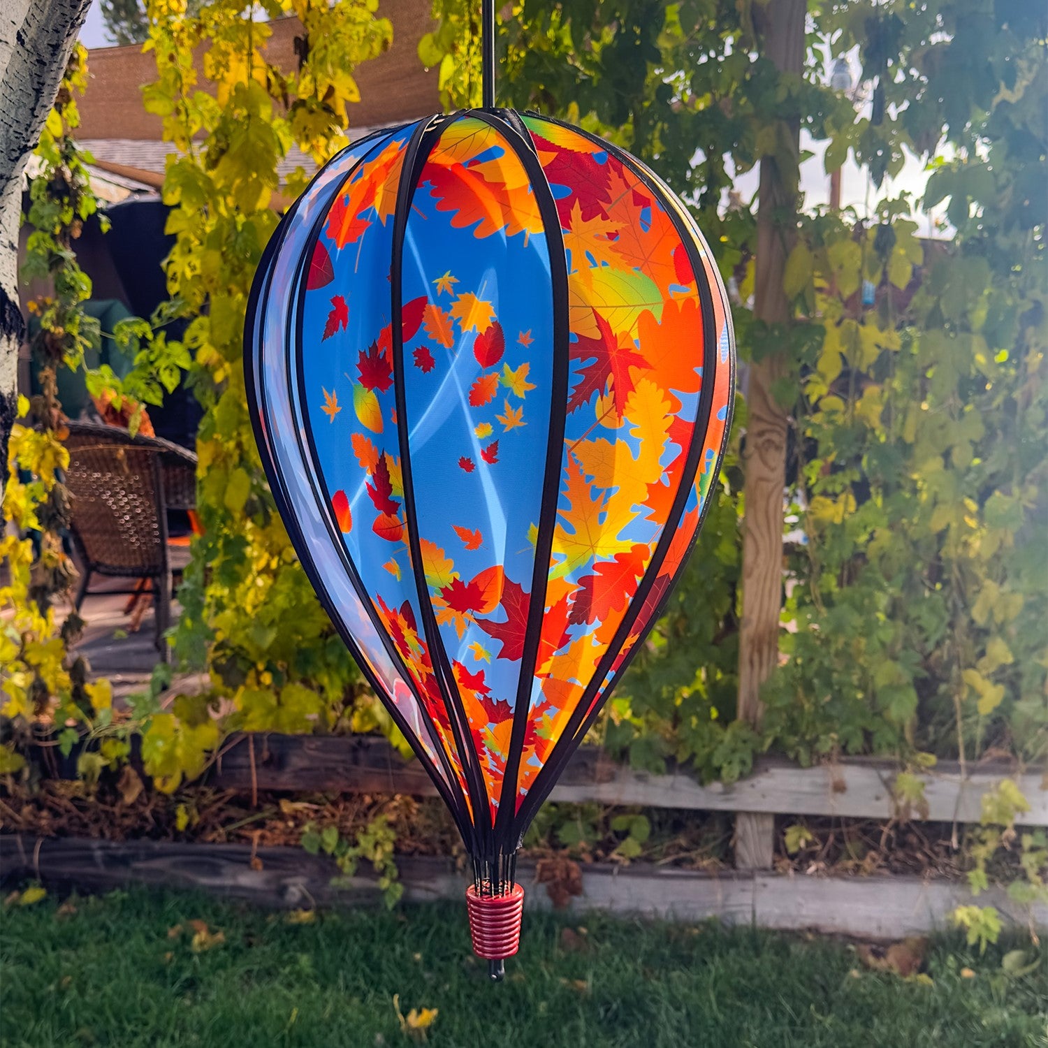 Fall Leaves 10-Panel Hot Air Balloon Spinner featuring colorful autumn leaves in motion, perfect for outdoor decoration and seasonal festivities, hanging from a garden hook.