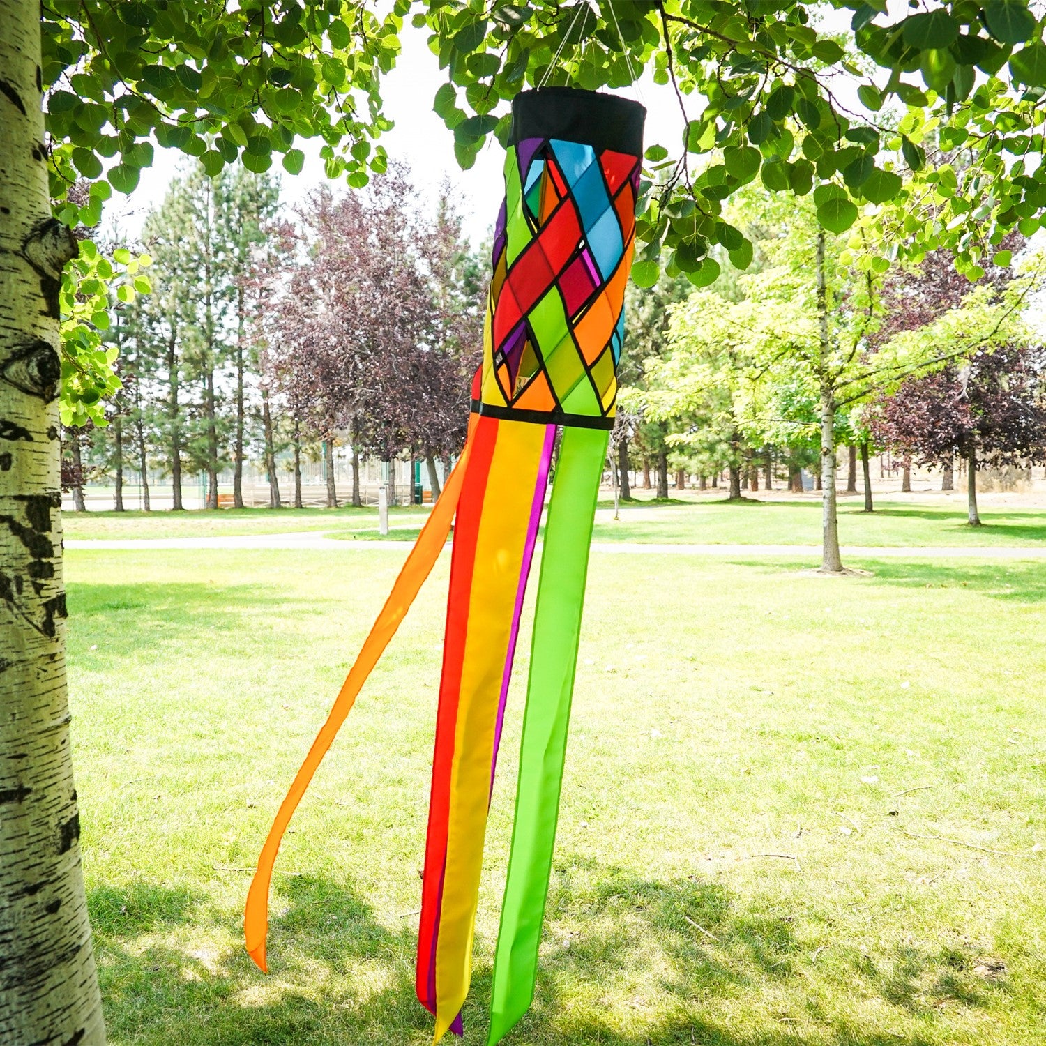 Fiesta Diagonal Weave 60\" Windsock with vibrant colors and black edging, fluttering in an outdoor setting against a bright blue sky.