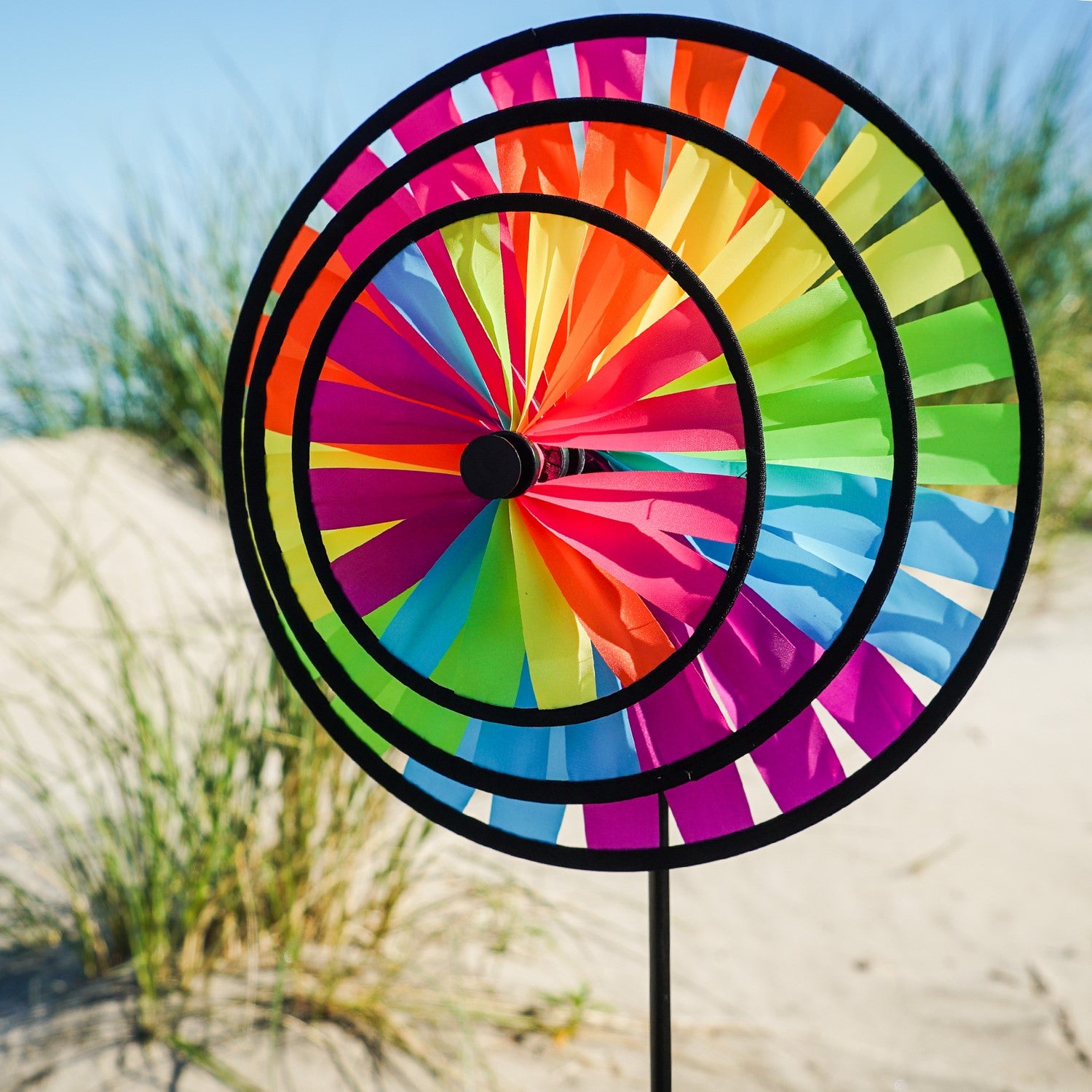 Fiesta Triple Wheel Spinner with three colorful wheels rotating in the breeze on a garden pole, showcasing a bright outdoor scene.