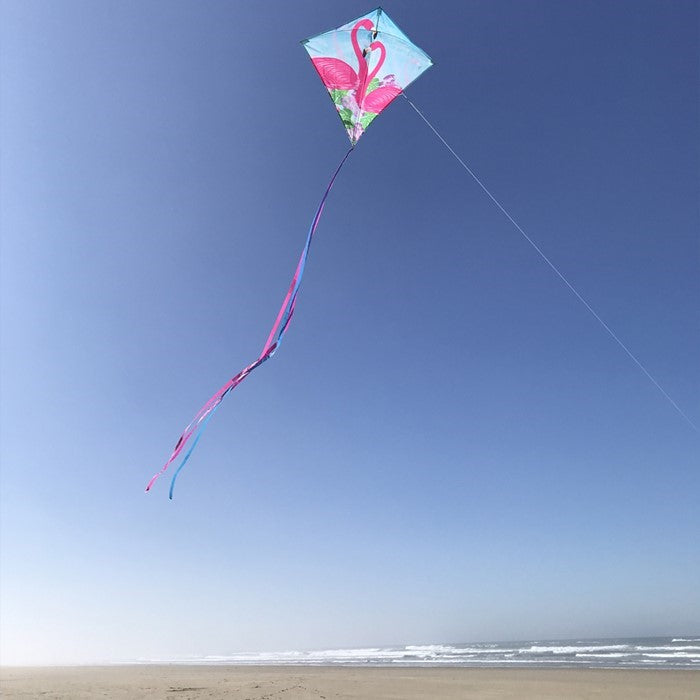 Flamingo 30-inch Diamond Kite with vibrant flamingo design flying in a clear blue sky, showcasing its colorful tails and lightweight build.