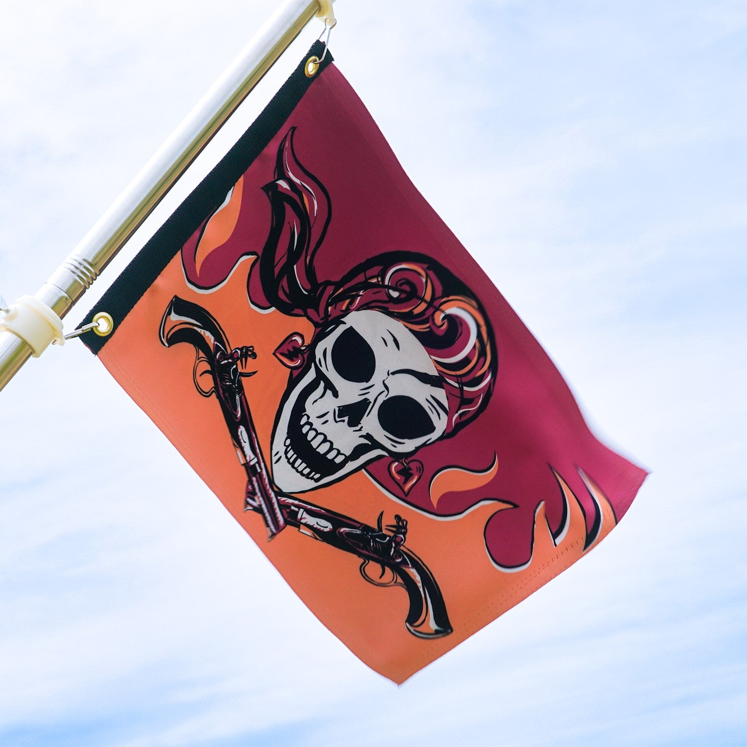 Flintlock Pirette Lustre 12x18 grommet flag displaying vibrant pirate-themed graphics, viewable from both sides, fluttering on an outdoor pole.