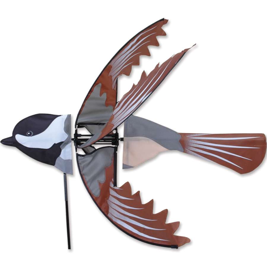 Flying Chickadee Spinner with colorful chickadee design spinning elegantly in a garden setting under blue skies.