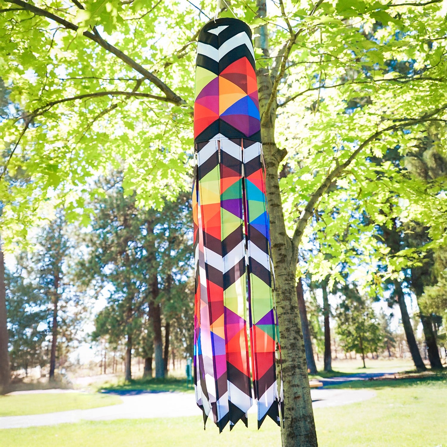 Geometric Black & White 40-inch Illusion Windsock hanging in a garden, featuring embroidered details and stunning printed tails creating a mesmerizing effect.