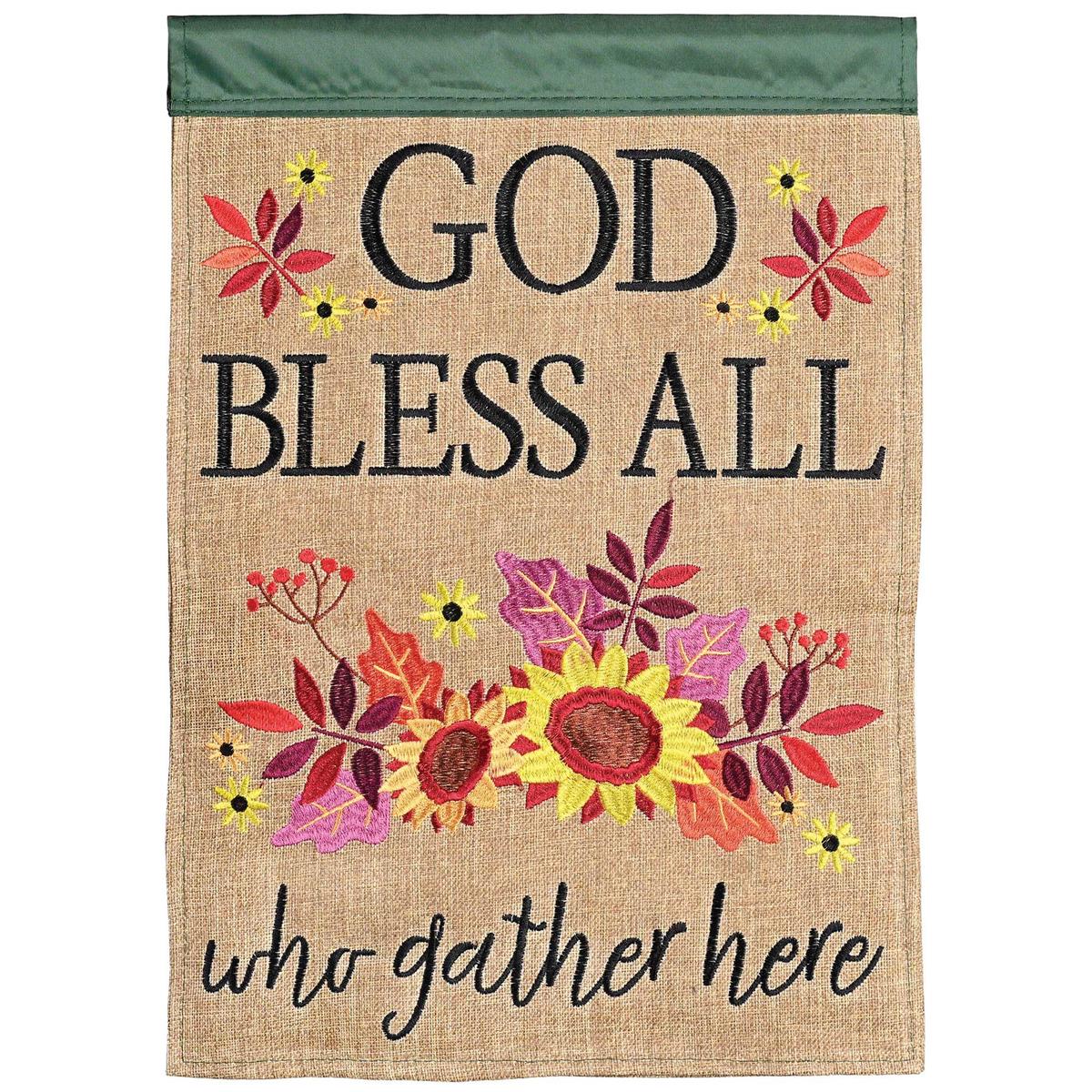 God Bless All Who Gather garden flag featuring charming applique design, displayed in a garden setting on a flagpole.