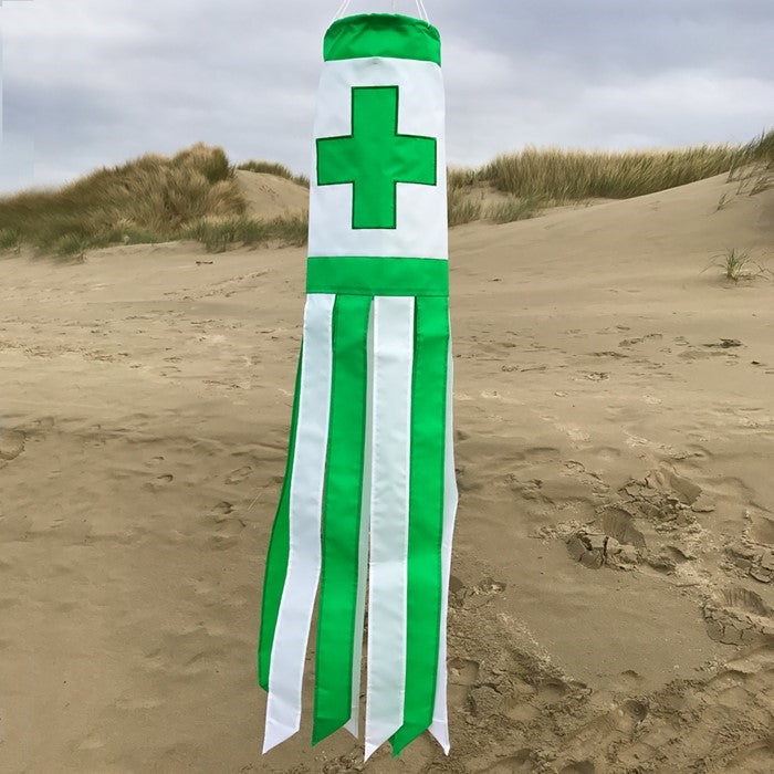 A Green Cross 40" Windsock adorned with an applique design, featuring fluttering tails in an outdoor setting, ideal for health and wellness.