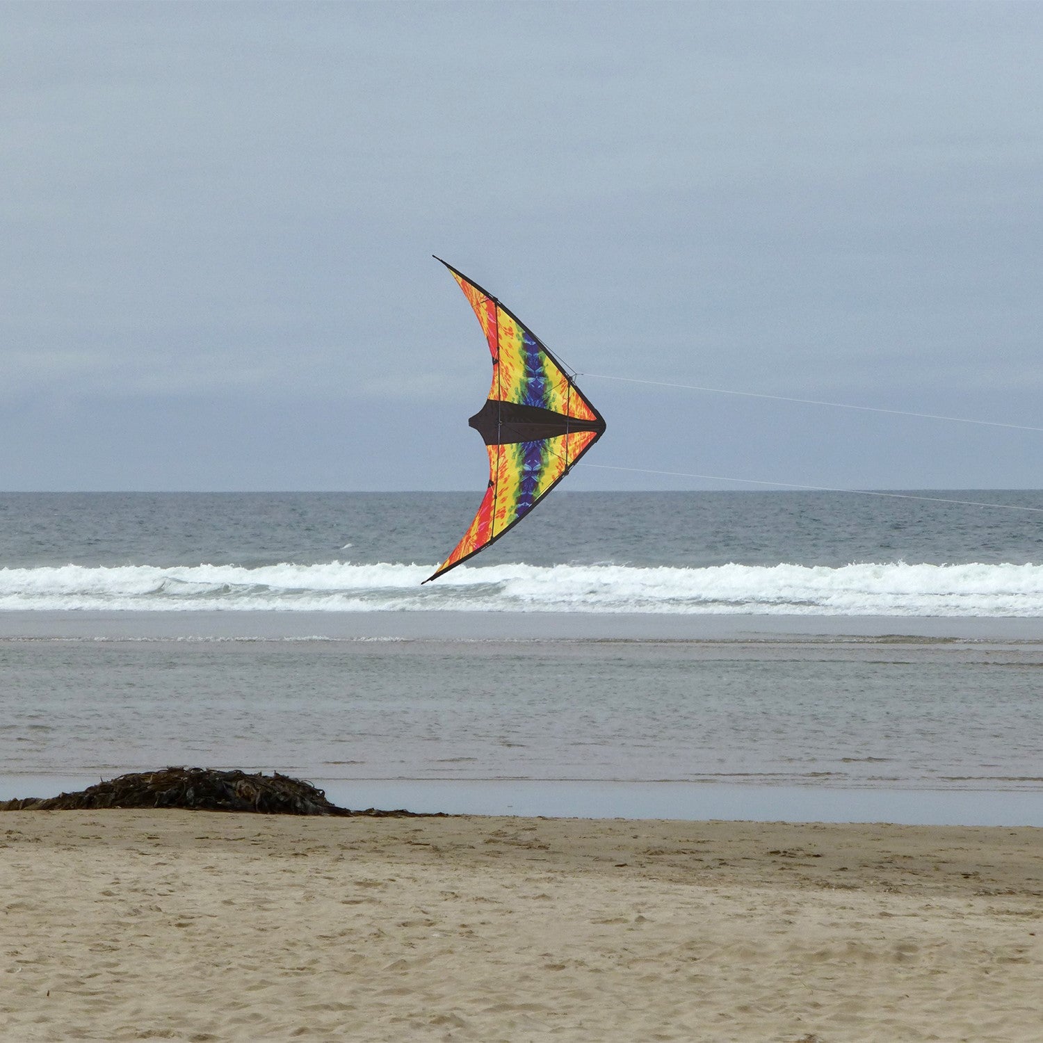 Groovy Stunter 48-inch Sport Kite featuring a colorful colorwave design, soaring against a clear blue sky during outdoor activity.