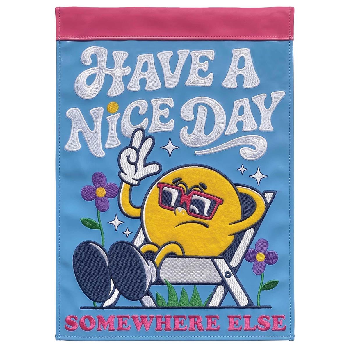 Have A Nice Day Somewhere garden flag, 13x18 inches, vibrant design with fabric applique and embroidery displayed in an outdoor garden setting.