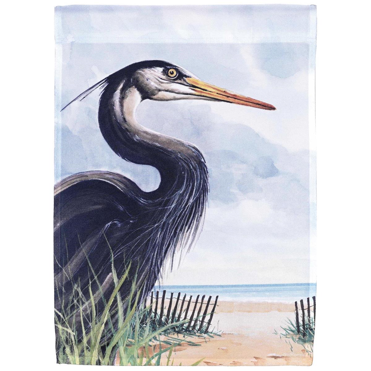 Heron Beach Patrol garden flag featuring a colorful heron design fluttering in the breeze, displayed in an outdoor garden setting.