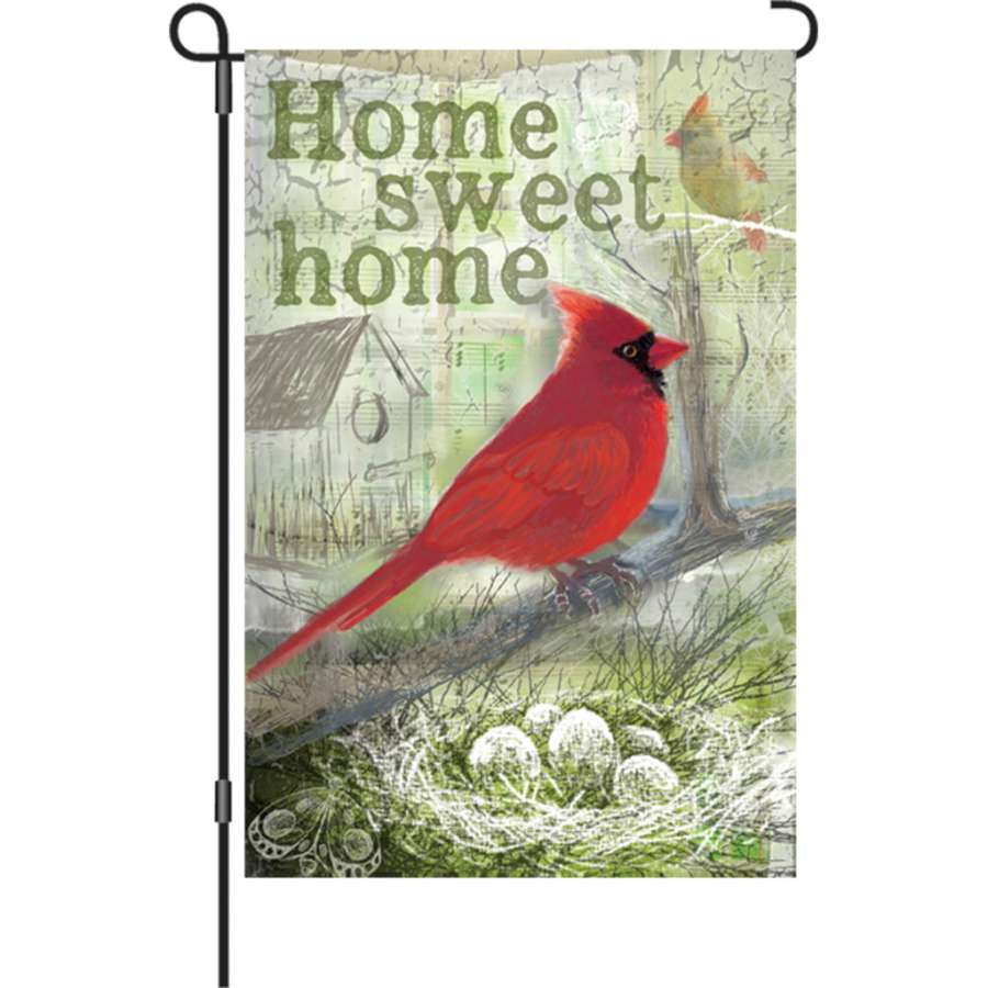 Home Sweet Home garden flag displaying vibrant colors and inviting lettering, made from PremierSoft fabric, fluttering in a landscaped garden.