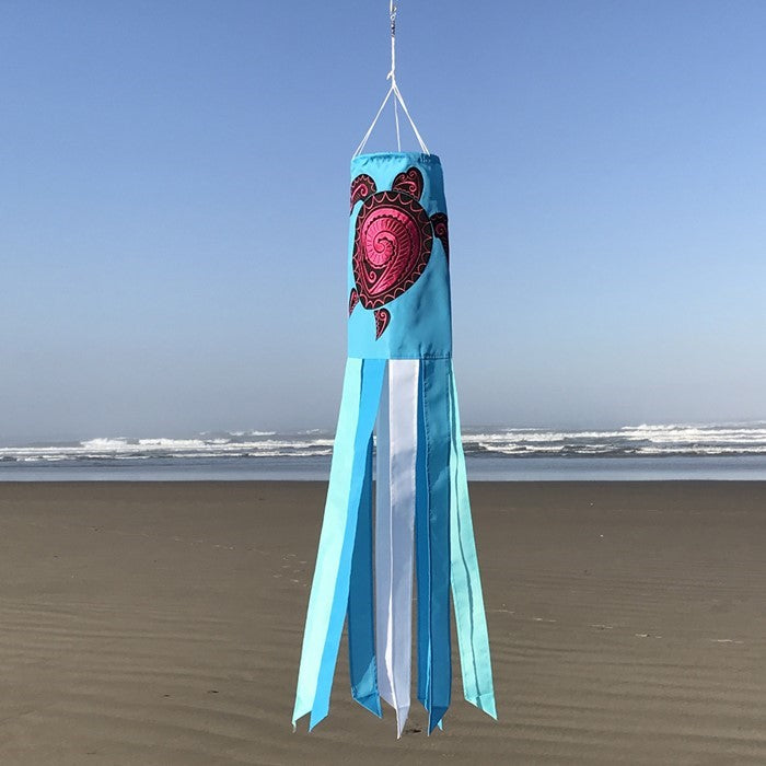 Honu (Turtle) 40-inch windsock with colorful Hawaiian design and vibrant embroidered accents fluttering in a gentle breeze in a garden setting.