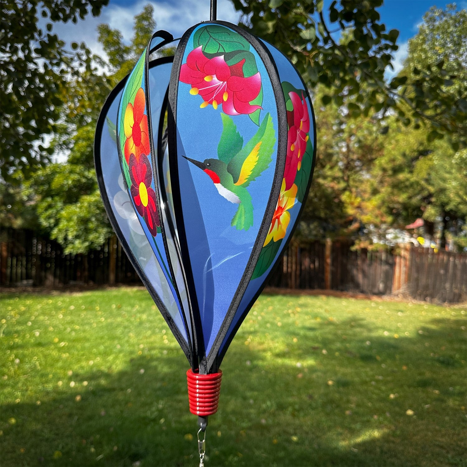 Hummingbird Flowers Hot Air Balloon spinner with colorful flower and hummingbird designs, spinning gracefully in an outdoor setting.