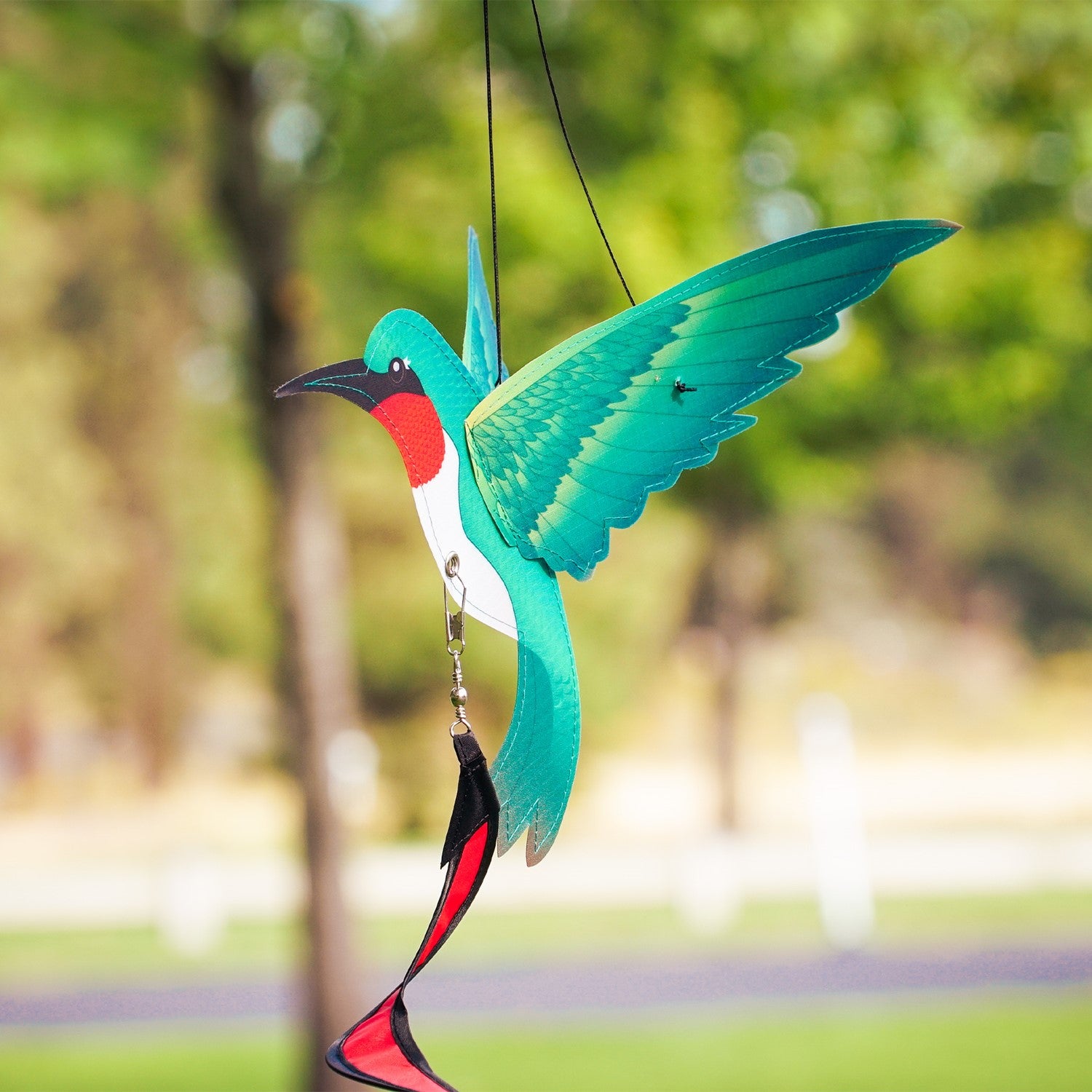 Hummingbird Theme Twister with moveable wings and curlie tail hanging in a garden, displaying vibrant colors and 3D design.