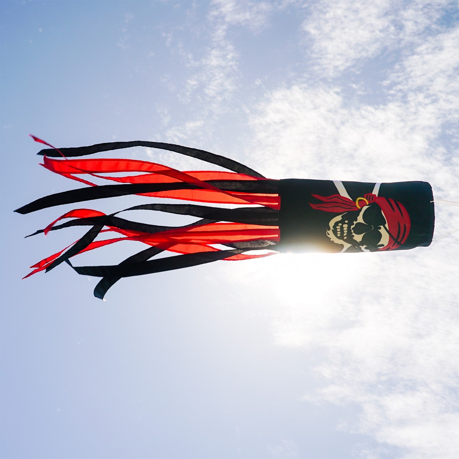 I'm a Jolly Roger 40" Windsock featuring a detailed pirate design with headscarf and gold earring, fluttering with vibrant tails in an outdoor setting.