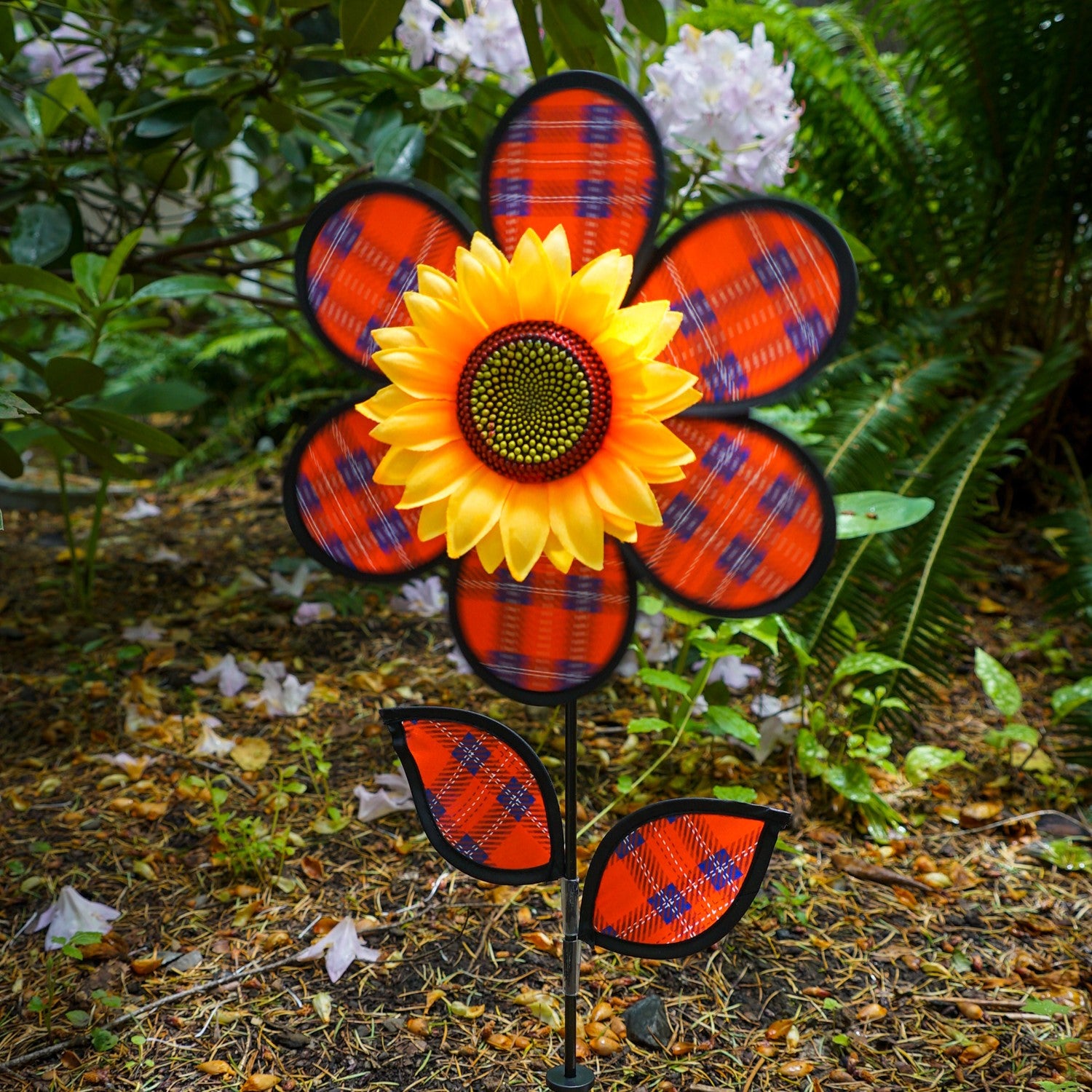 Alt text: "12-inch Red Plaid Flower with Leaves garden spinner featuring vibrant plaid petals and detailed sunflower center, displayed outdoors.