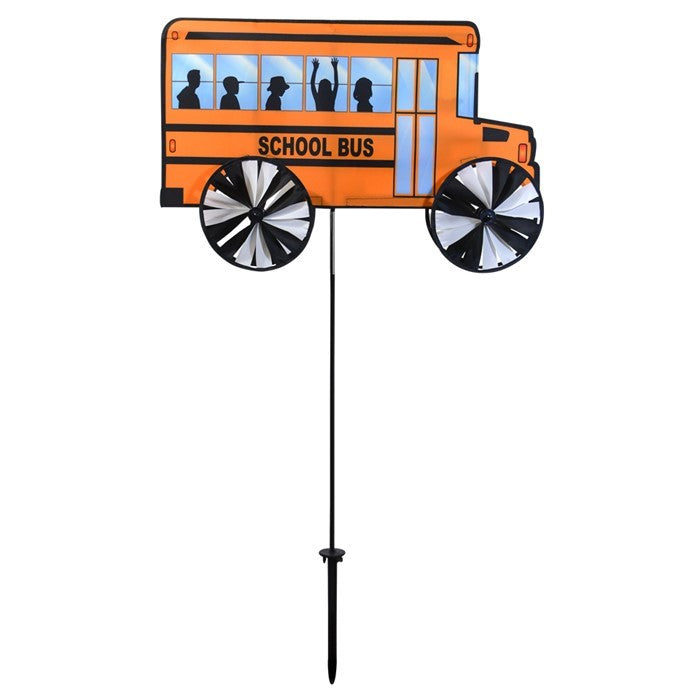 Alt Text: "24-inch school bus spinner with vibrant yellow design and colored wheels, spinning in a garden setting on a bright sunny day.