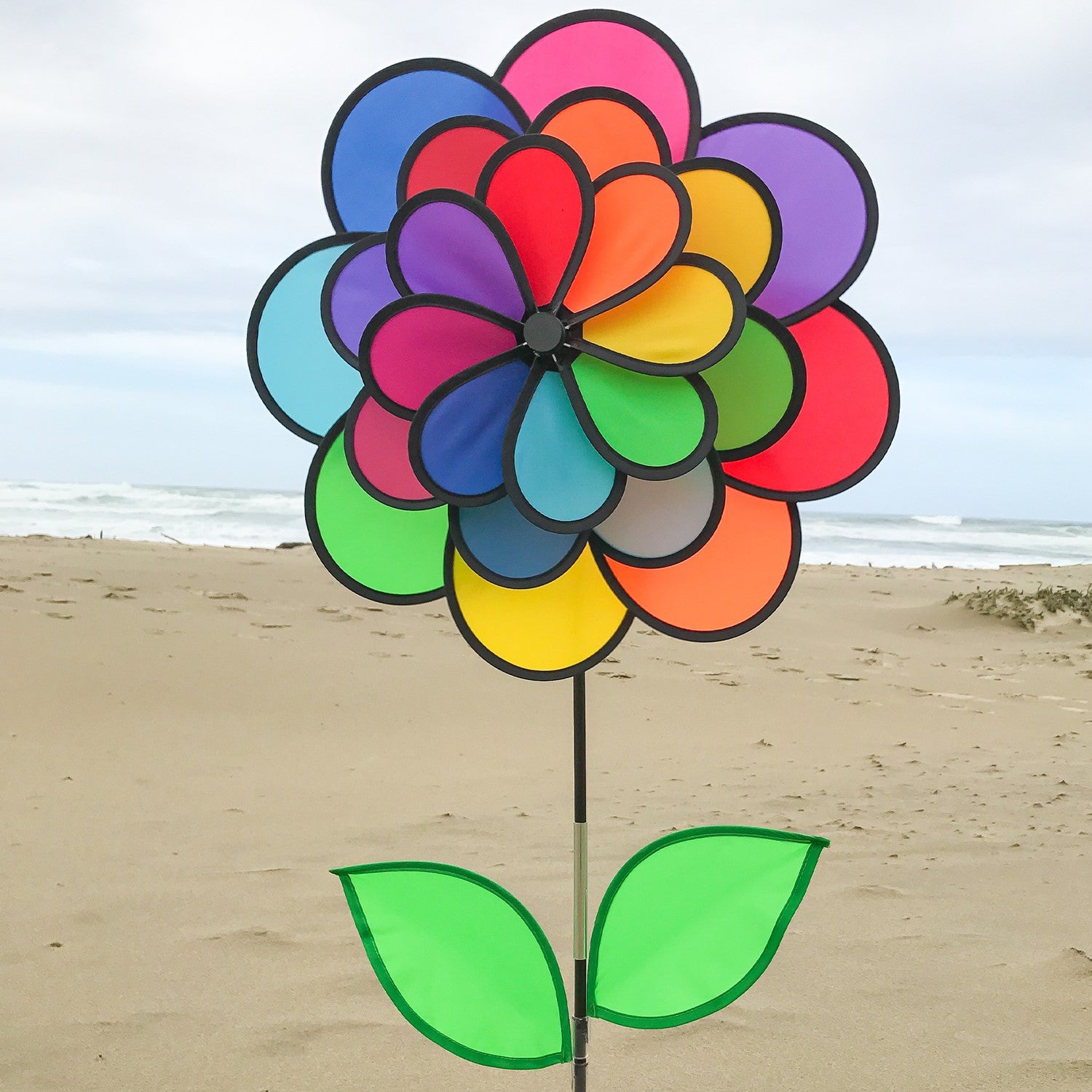 Alt Text: "Vibrant 24 Petal Flower spinning in the garden with colorful petals and leaves attached to a fiberglass stem, showcasing a delightful outdoor decor option.