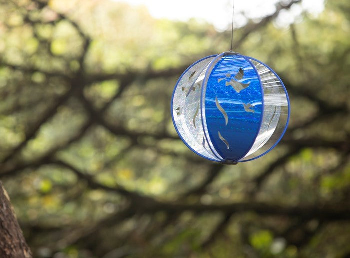 Alt Text: Blue Peace Angel Spinning Globe with six poly panels, featuring serene angel design, displayed outdoors, sparkling in sunlight.