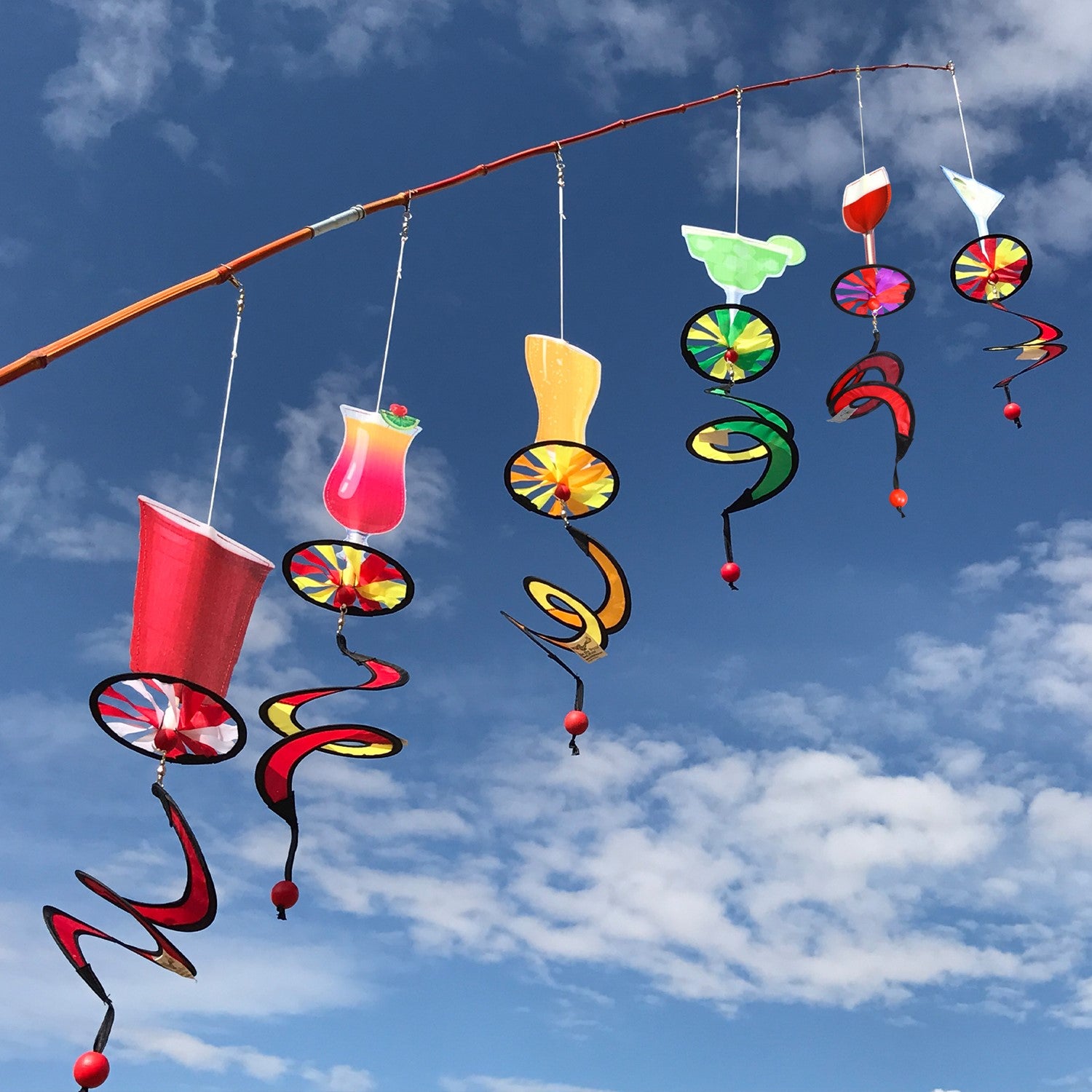 Alt Text = "Mini Cocktail 5 O'Clock Drink Spinner featuring a colorful cocktail glass design with a curlie tail, spinning in a garden setting.