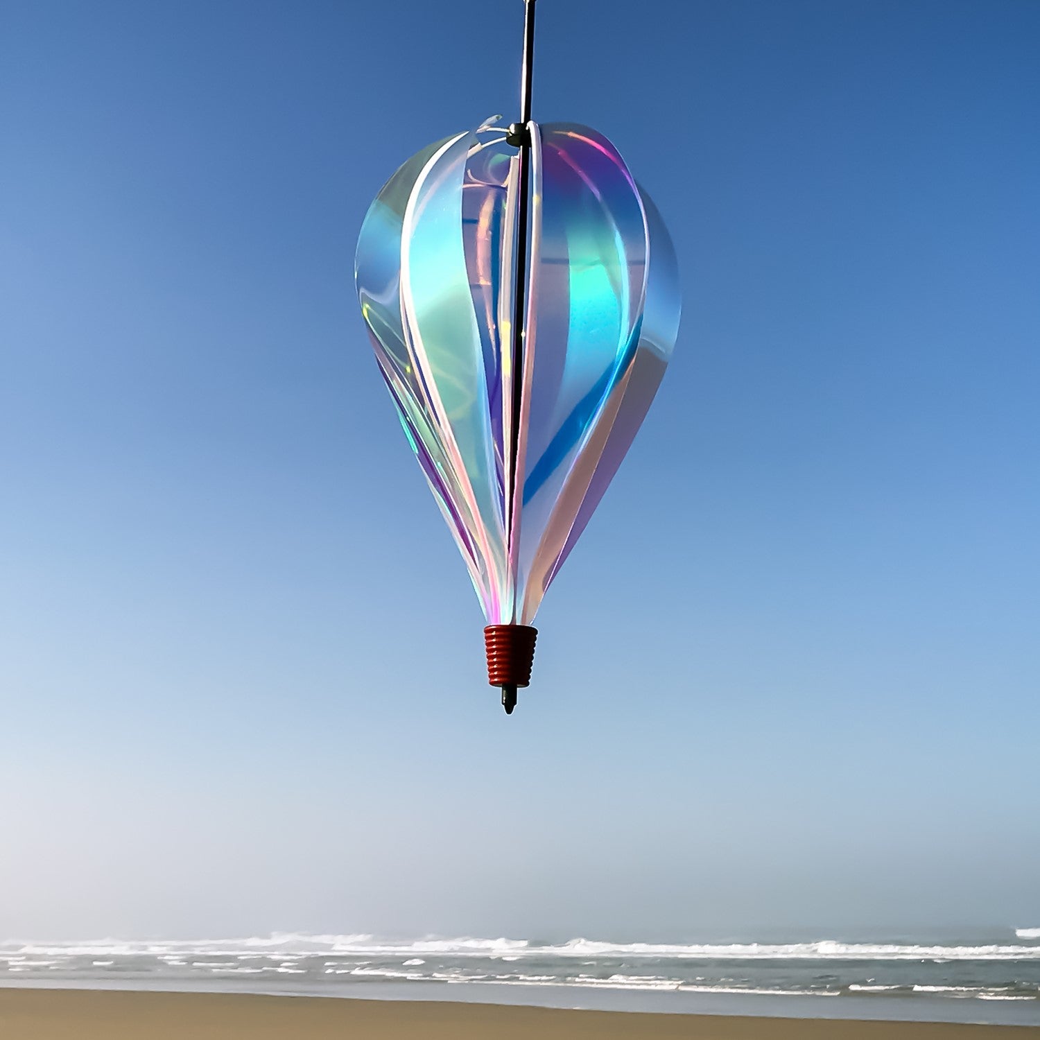 Iridescent 6-Panel Hot Air Balloon spinner gracefully spinning in an outdoor garden setting, showcasing its vibrant and colorful panels.
