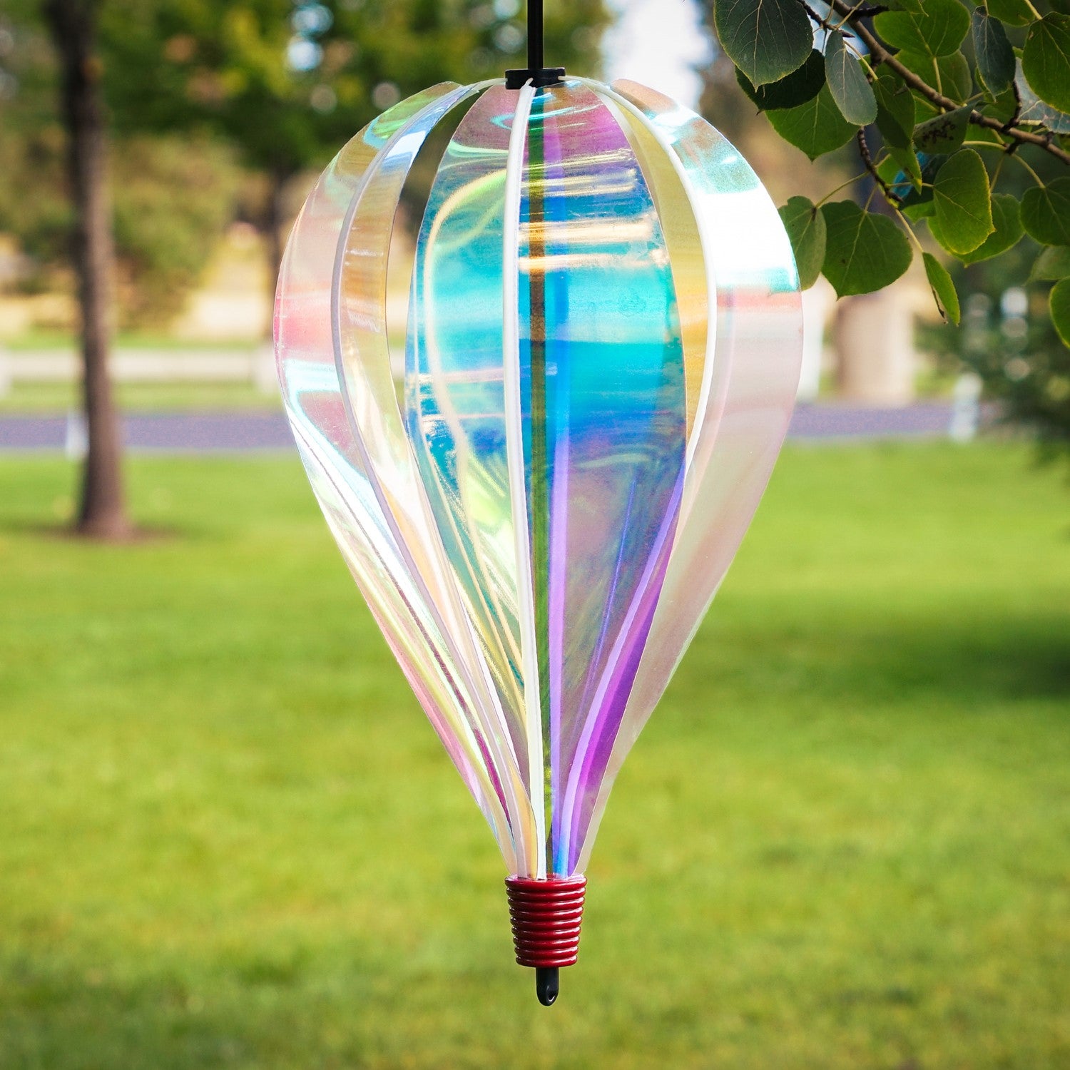 Iridescent 6-Panel Hot Air Balloon spinner gracefully spinning in an outdoor garden setting, showcasing its vibrant and colorful panels.