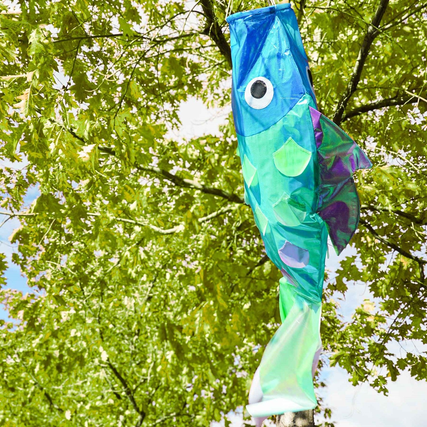 48-inch Iridescent Cool Damsel Fish Windsock displaying shimmering scales in a garden setting, showcasing its unique colors under sunlight.