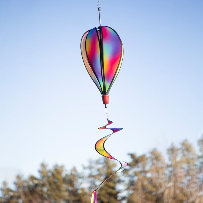 Jewel 6-Panel Hot Air Balloon spinner featuring a rainbow design, spinning gently in the breeze against a clear blue sky outdoors.