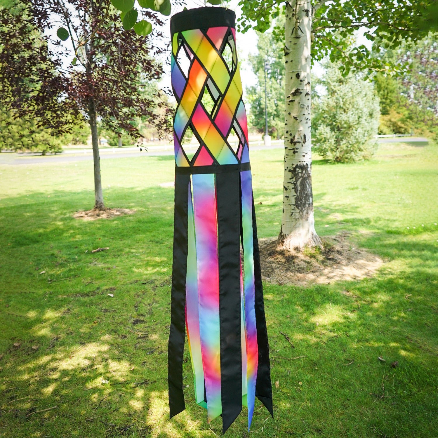 Jewel Diagonal Weave 40-inch windsock with bright jewel colors and black tails, fluttering in a light breeze, displayed in a garden area.