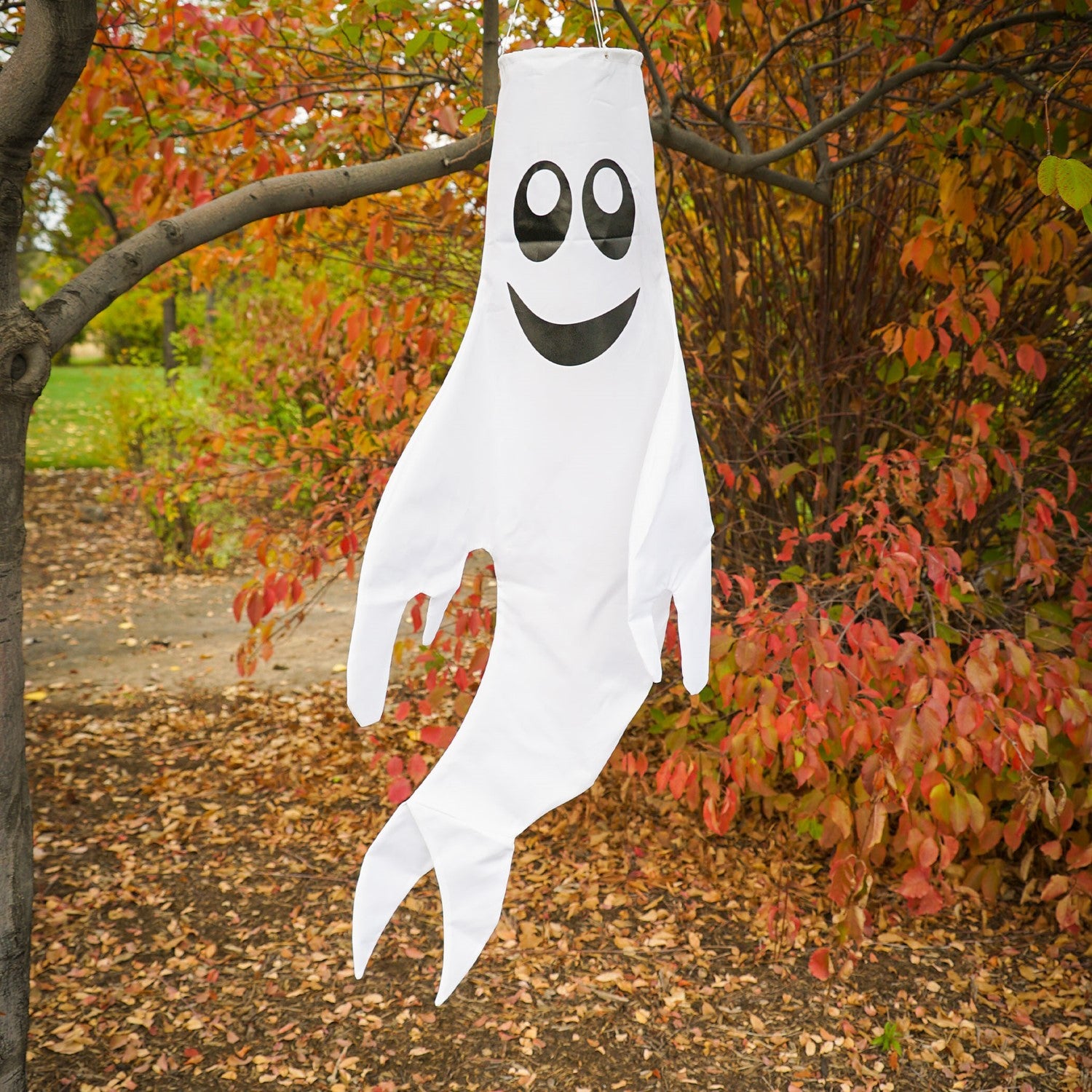 Large Ghost Windsock with a grinning face, made from heavy-weight polyester, fluttering in the breeze, perfect for Halloween and fall decorations.