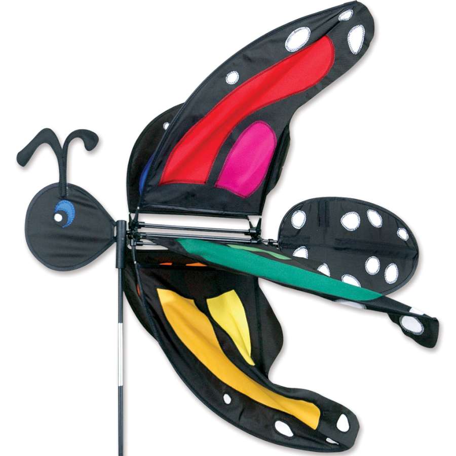 Large Lady Rainbow Monarch Spinner featuring a colorful butterfly design, spinning in the breeze within a garden setting.