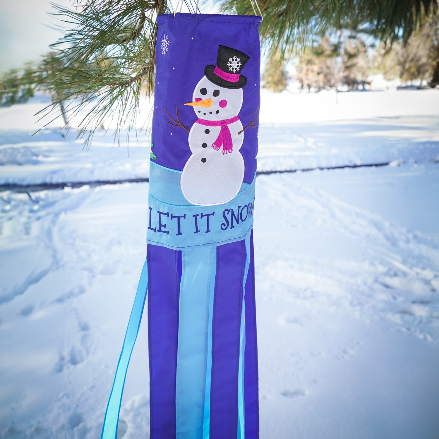 Let It Snow windsock featuring a cheerful snowman design with fluttering tails, perfect for festive winter outdoor decor that adds seasonal charm.