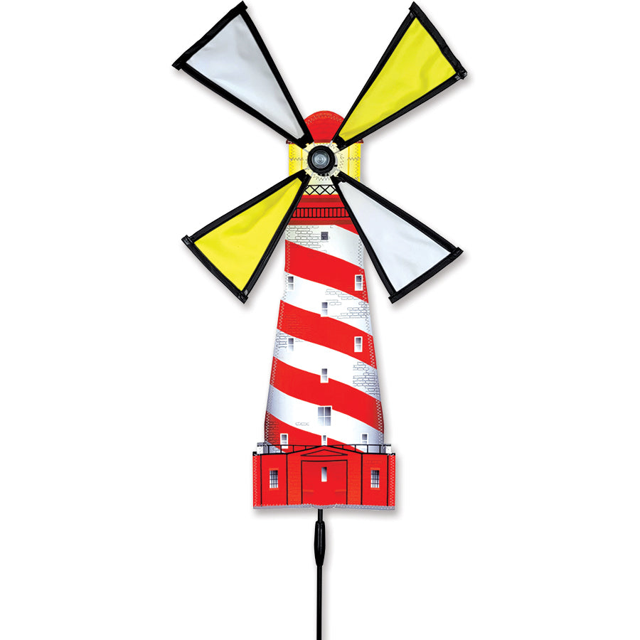 Lighthouse Spinner - White Shoal in a garden setting, featuring a vibrant lighthouse design that spins gracefully in the wind.