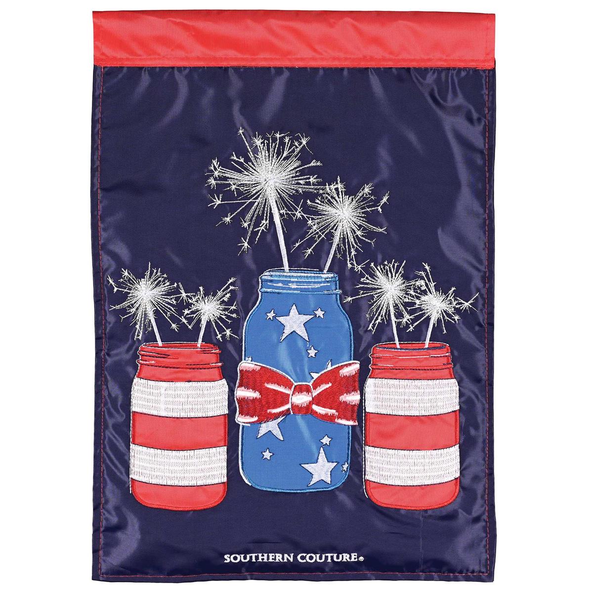 Mason Jar Sparklers garden flag featuring a glowing mason jar design displayed in a garden, showcasing vibrant colors and intricate embroidery.