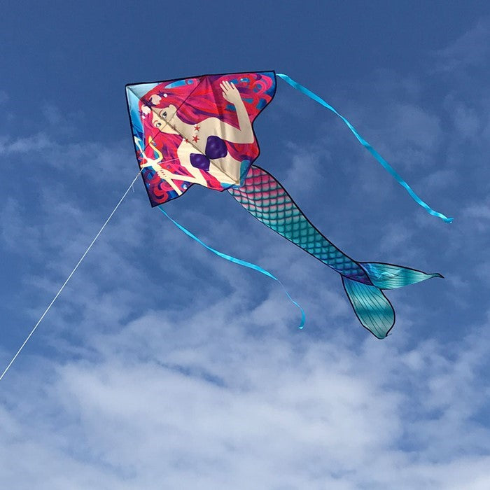 Mermaid 45' Fly-Hi Kite soaring in the blue sky with vibrant design and colorful streamer tails in a family-friendly outdoor setting.