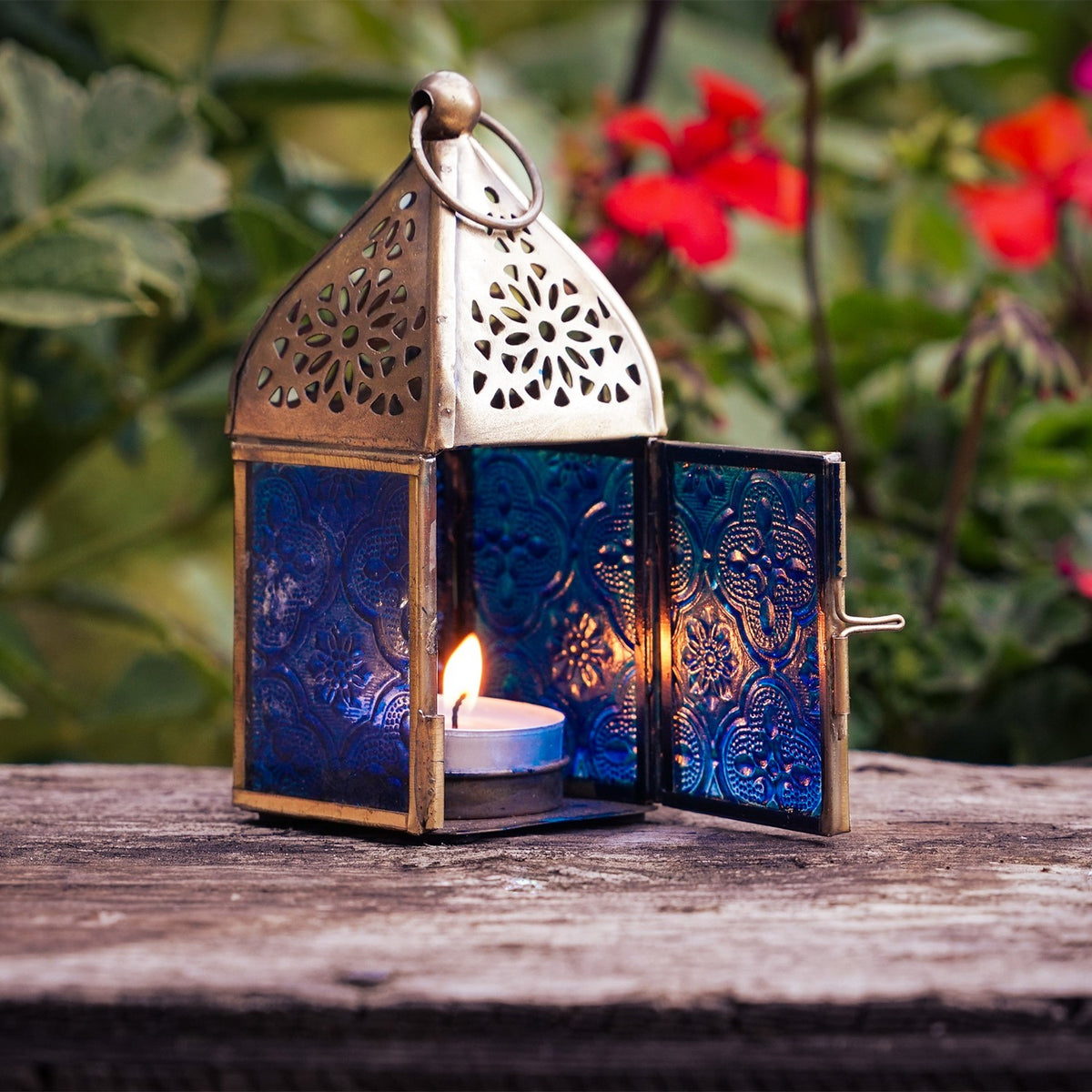 Mini Blue Square Glass Tealight Lantern with textured blue glass panels and a brass top, perfect for creating ambient lighting both indoors and outdoors.