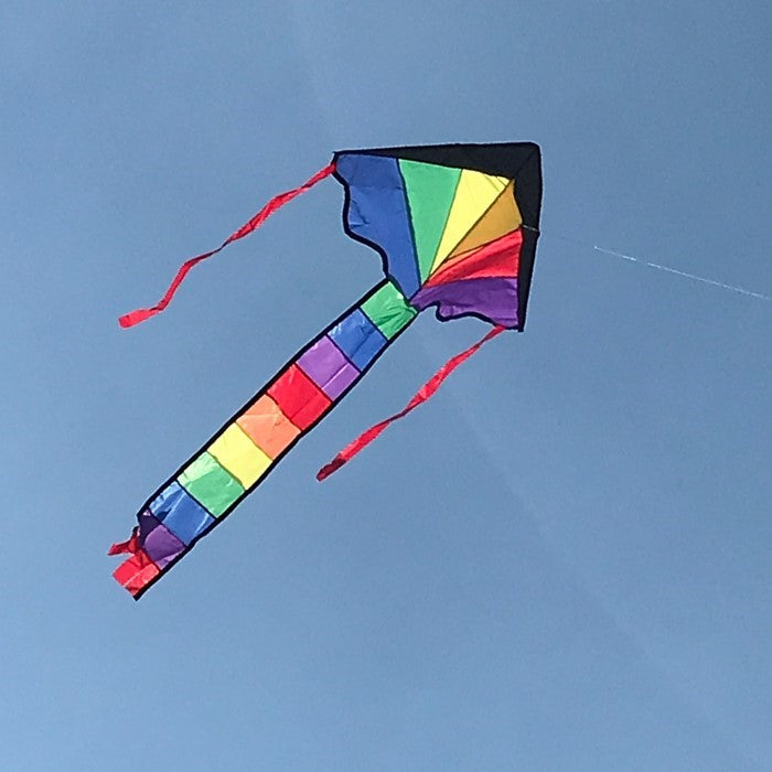Brightly colored Mini Rainbow Fly-Hi Kite featuring a rainbow design flying in blue sky with streamer tails trailing behind it.