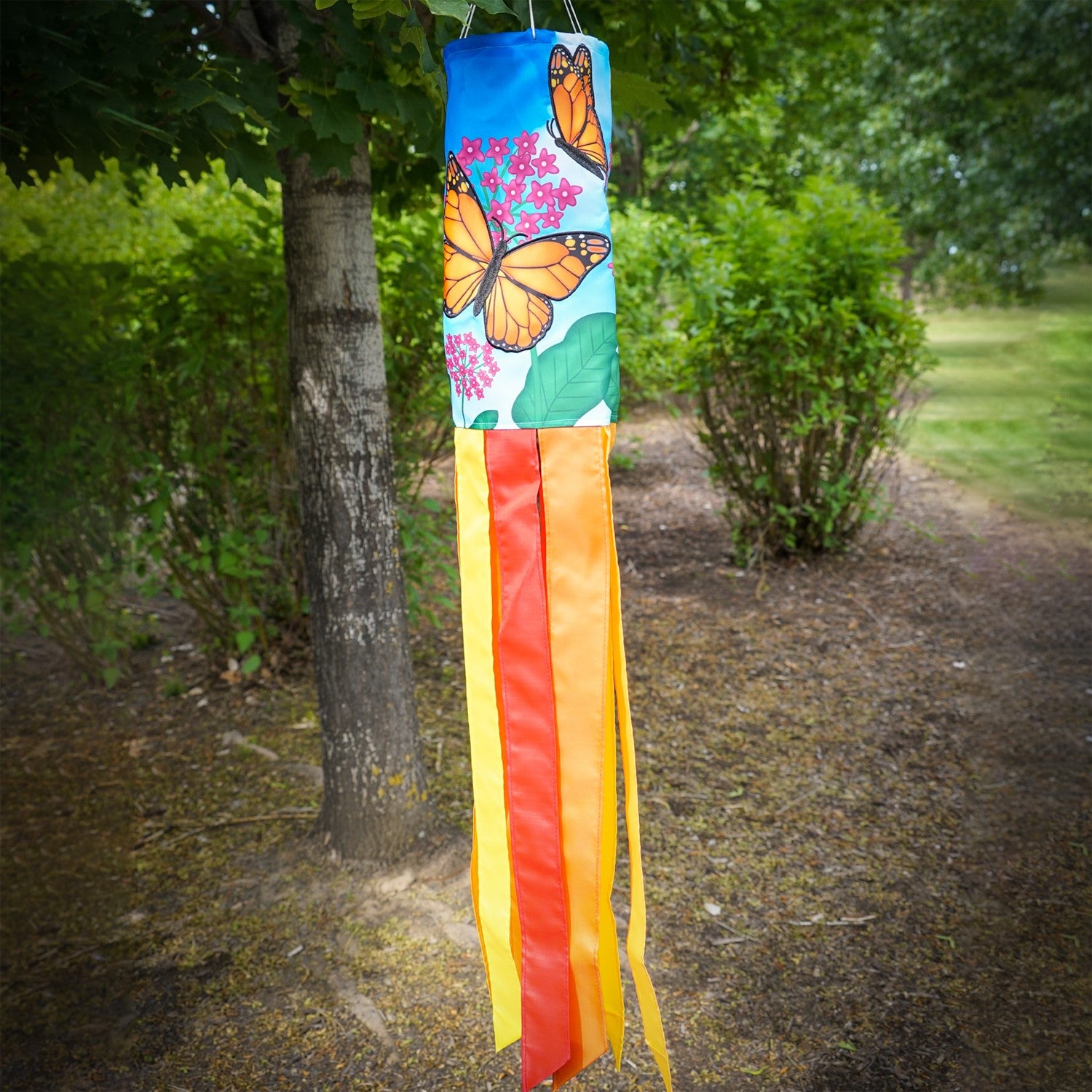 Monarch Butterfly 40" Inspiration Windsock featuring vibrant butterfly design and fluttering tails, displayed in an outdoor garden setting.