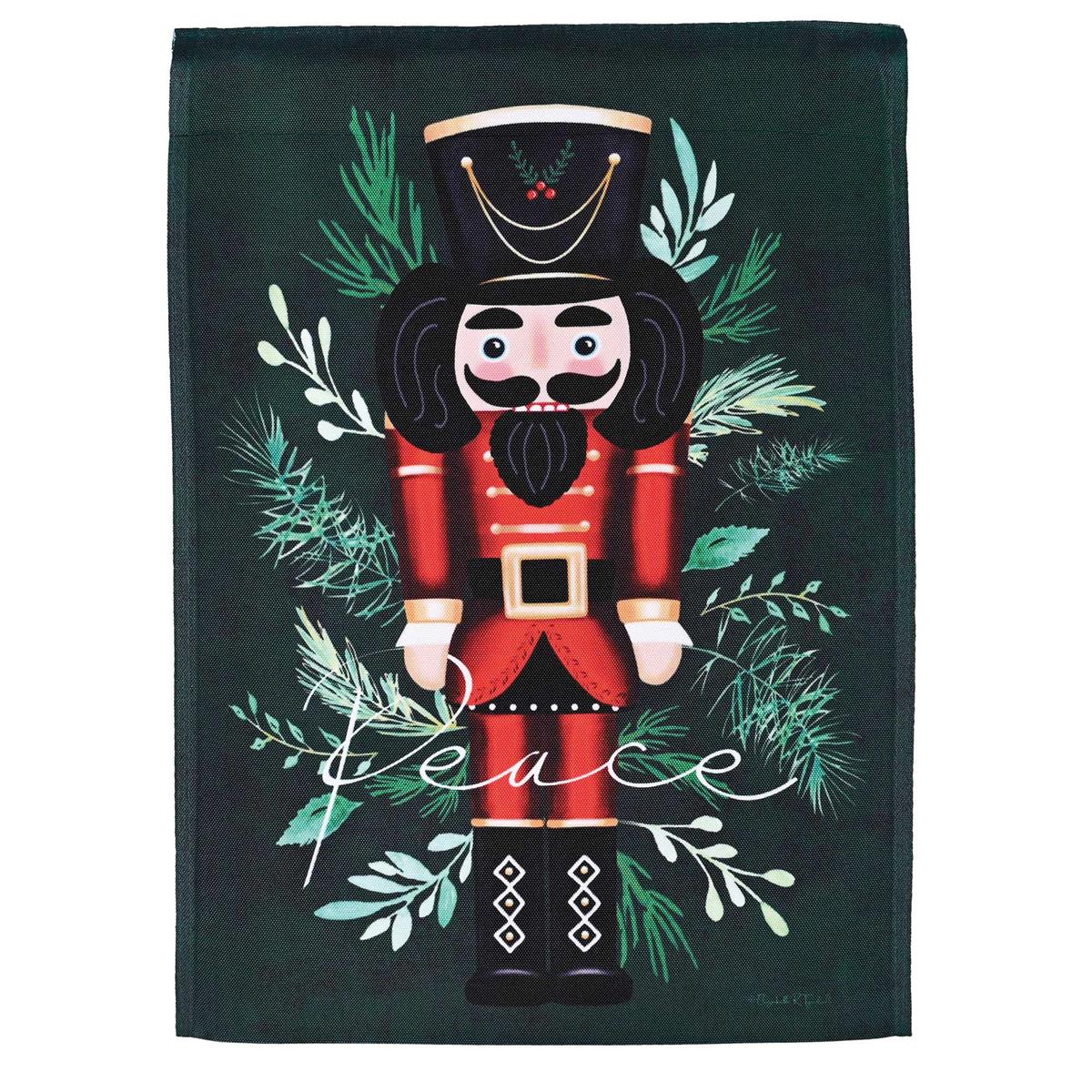 Nutcracker Peace Garden Flag measuring 13x18 inches, featuring a colorful design, displayed on a garden flag stand in an outdoor setting.