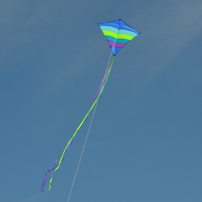 The Ocean Arch 39" Diamond Kite features a stunning blue and ocean-themed design, showcasing its durable ripstop fabric and long tails as it soars high in clear skies.