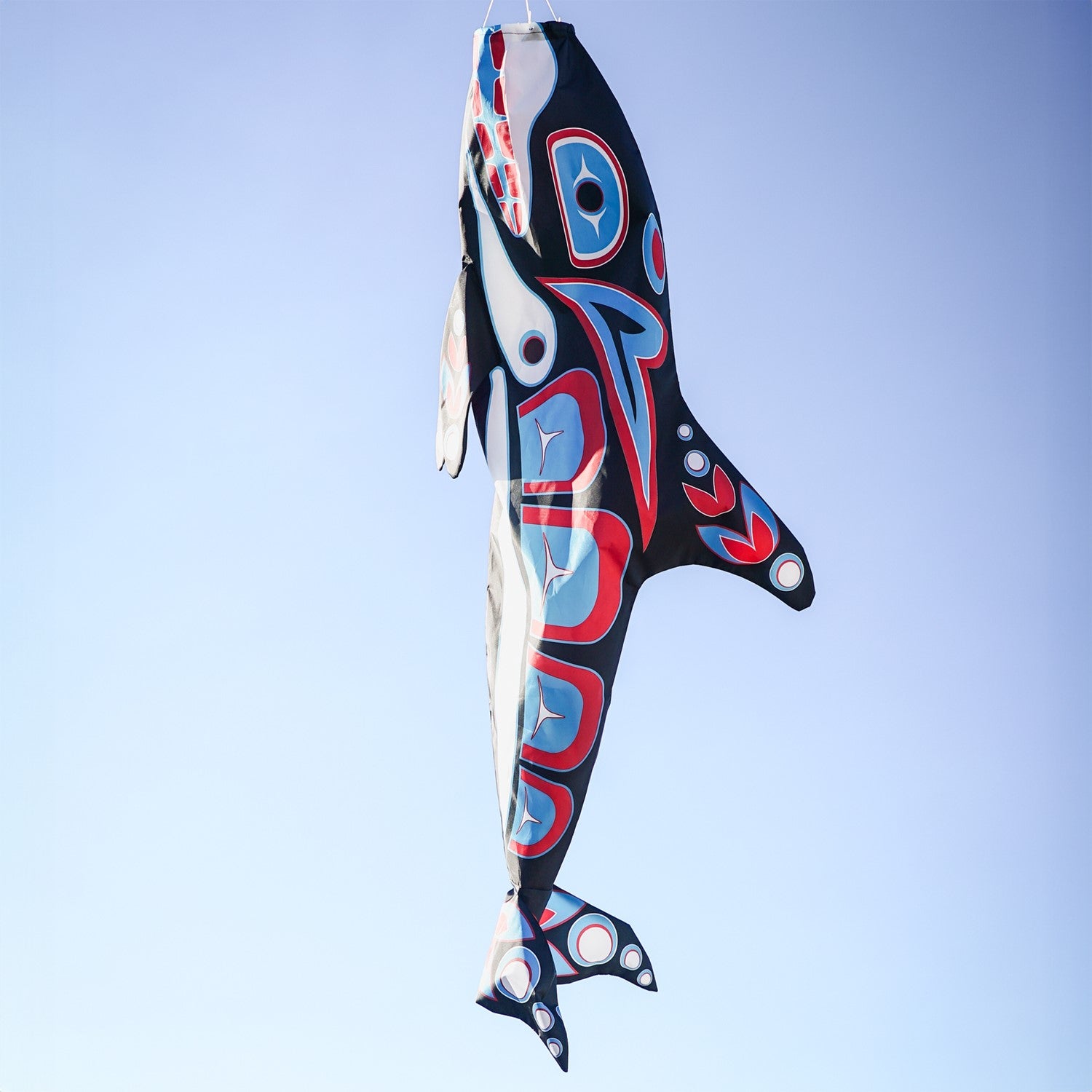 Orca Totem 48" Fish Windsock featuring intricate indigenous design, displayed in an outdoor setting, moving with the breeze.