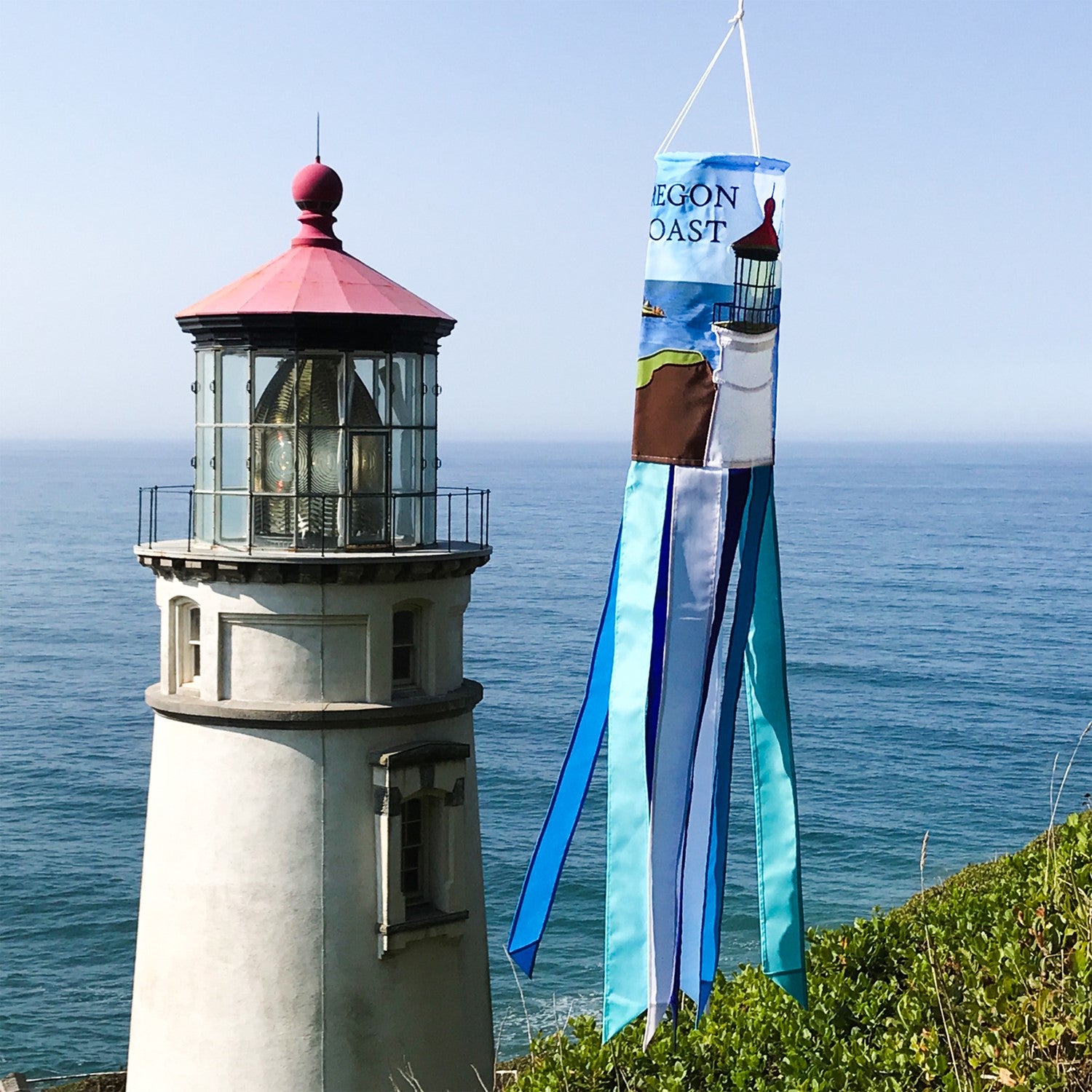 Oregon Coast 40-inch windsock featuring Heceta Head Lighthouse design with colorful applique and embroidered accents fluttering in the breeze.