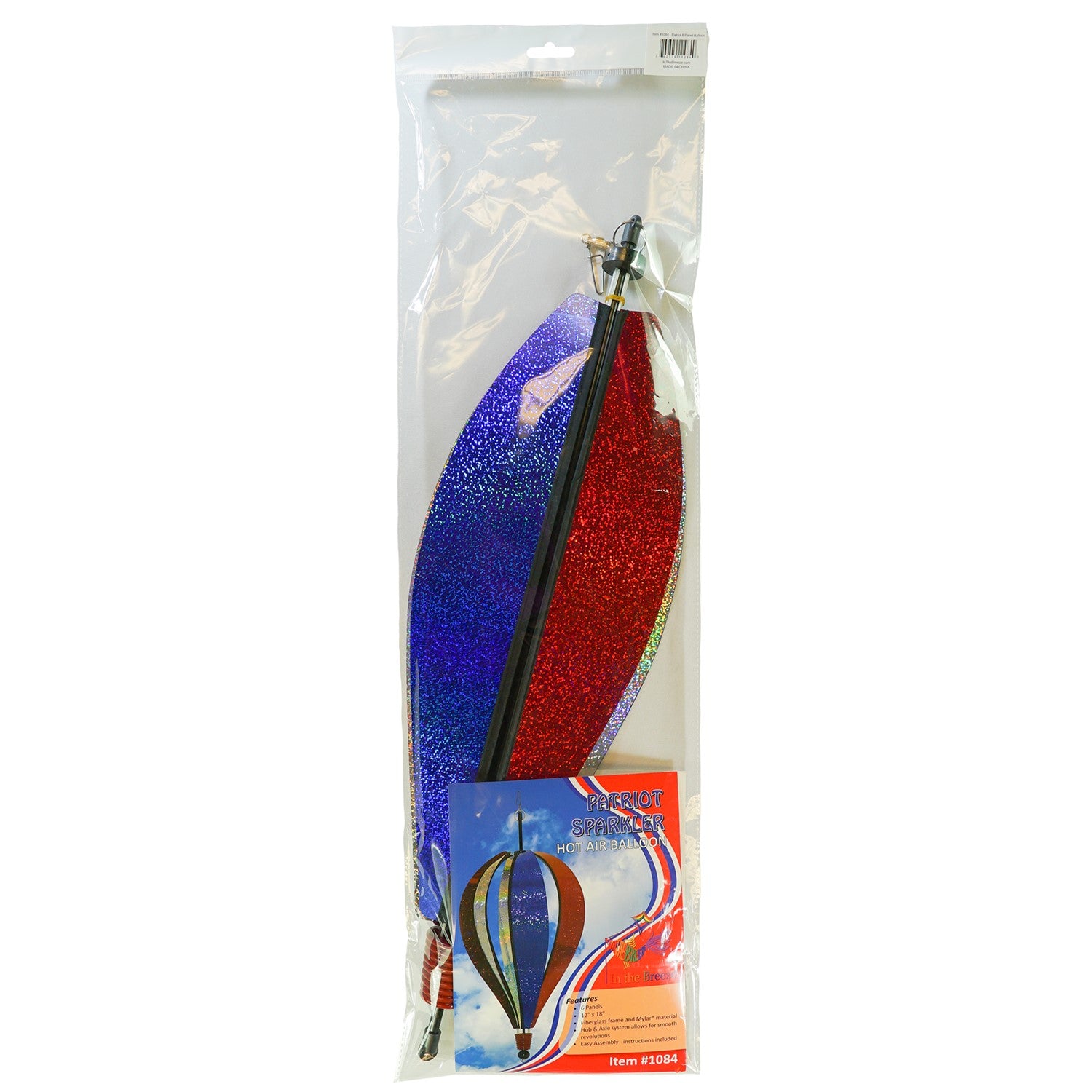 Patriot Sparkler 6-Panel Hot Air Balloon spinning in a garden, showcasing its vibrant red, white, and blue Mylar design against a blue sky.