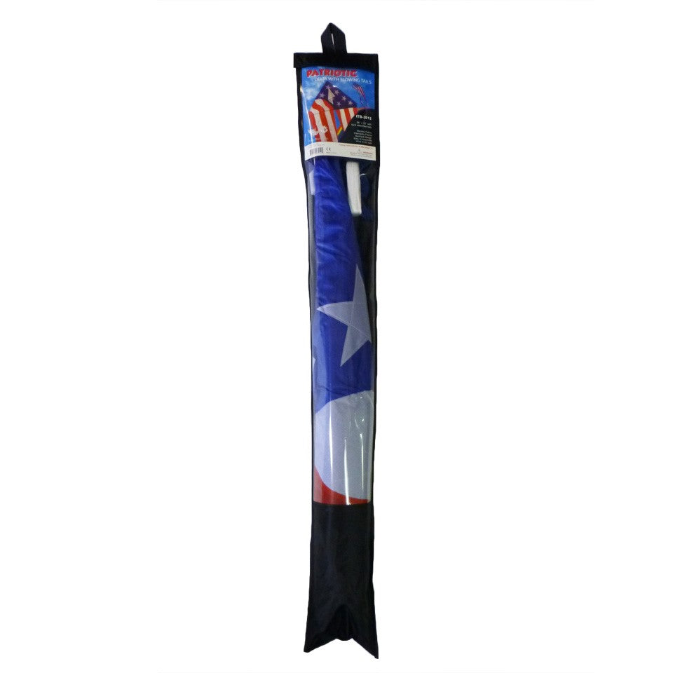 Patriotic 56" Delta kite featuring red, white, and blue stars and stripes with long tails, soaring in bright blue sky against a backdrop of fluffy clouds.