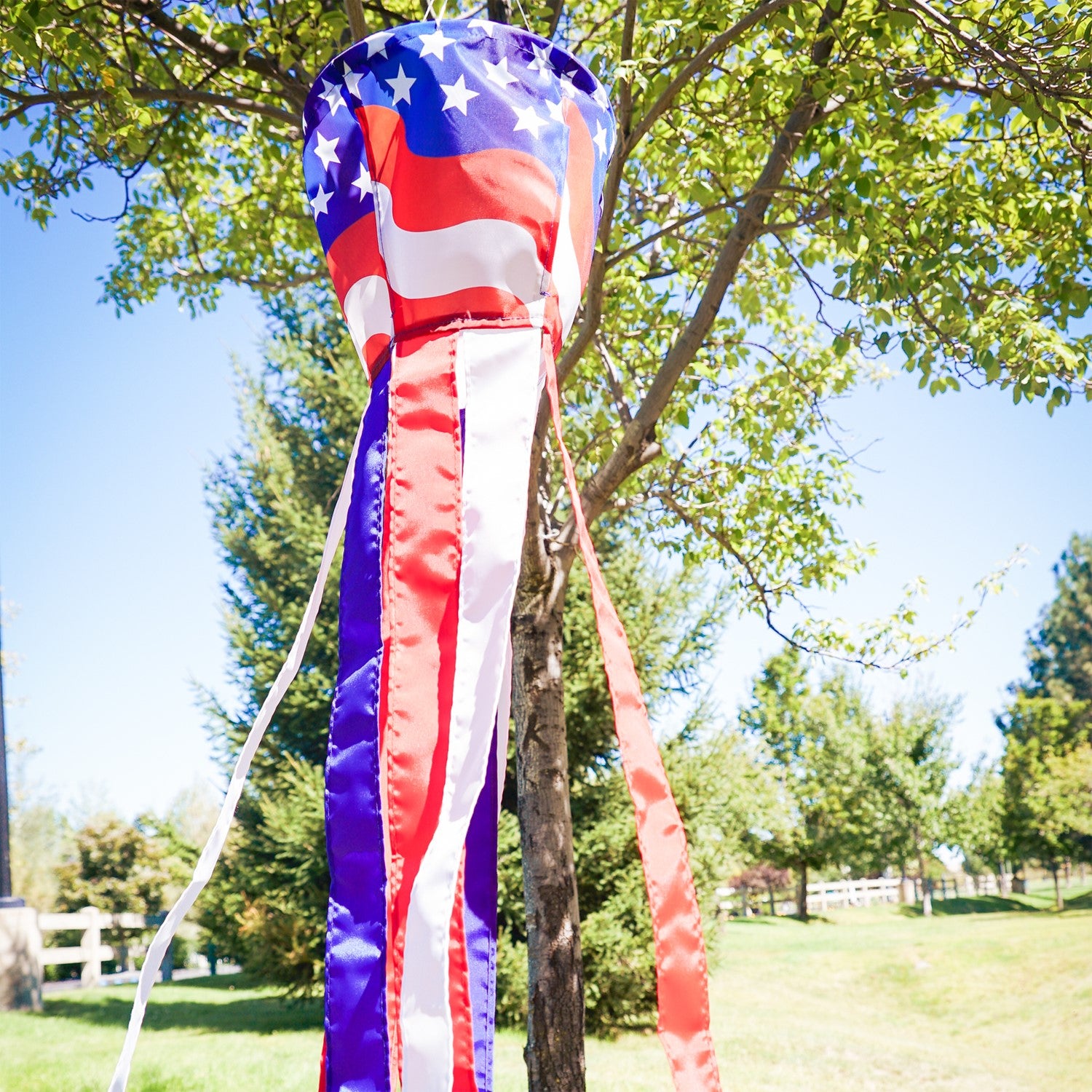 Patriotic Spinning Windsock featuring red, white, and blue stars and stripes design spinning in the outdoor breeze, adding vibrancy to the yard.