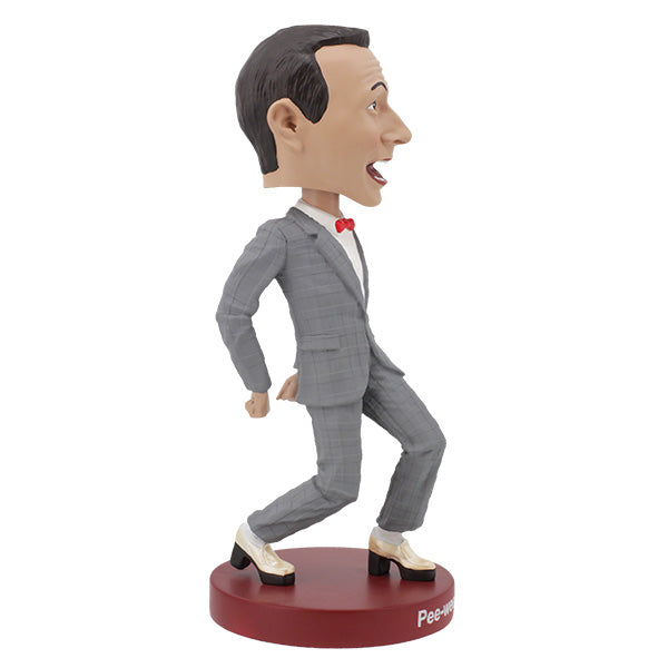 Pee-Wee Herman Bobblehead, standing 7 inches tall in a gray suit and red bowtie, featuring a playful expression, displayed on a decorative shelf.