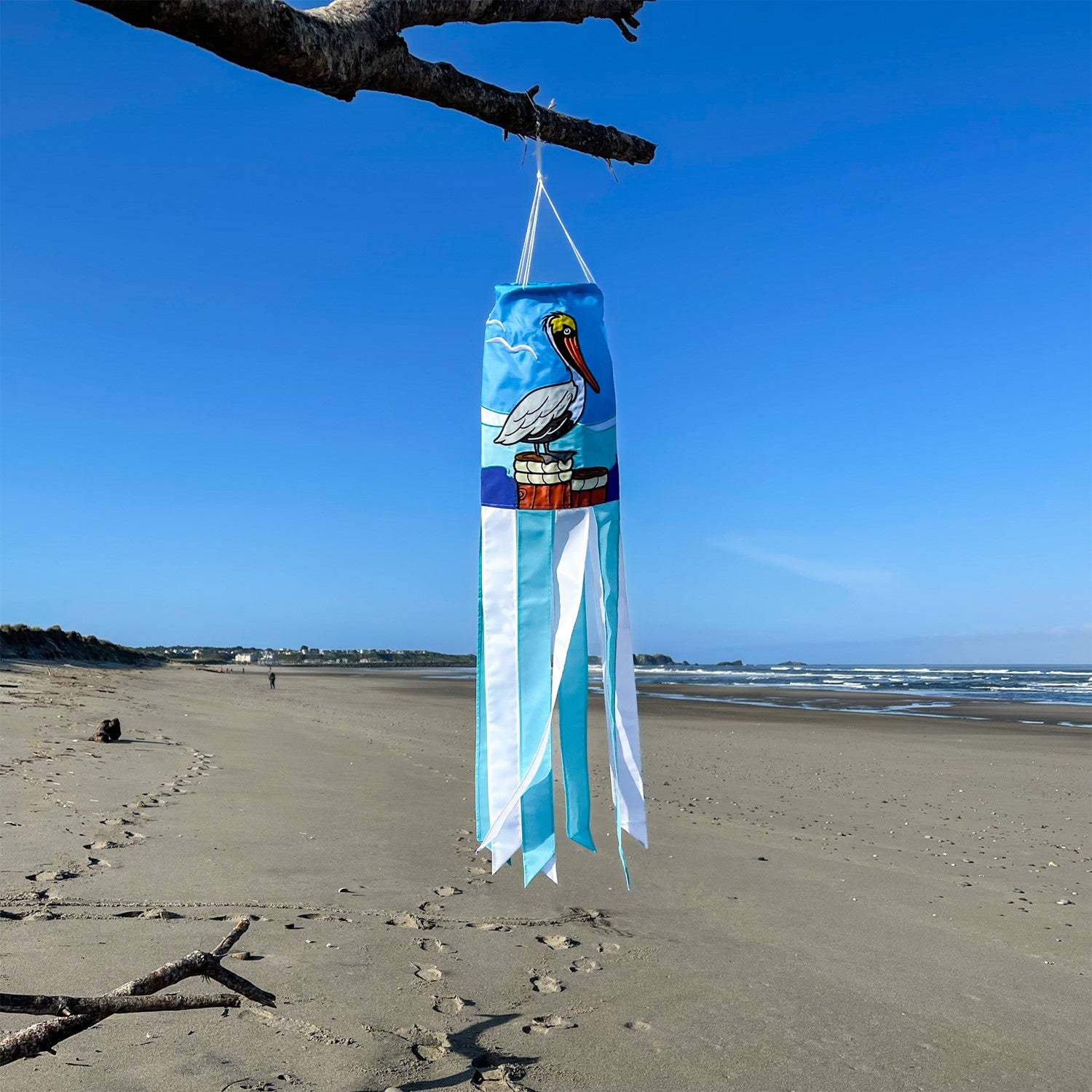 Pelican 40" Windsock showcasing a colorful pelican design with fluttering tails, displayed outdoors against a sunny backdrop.